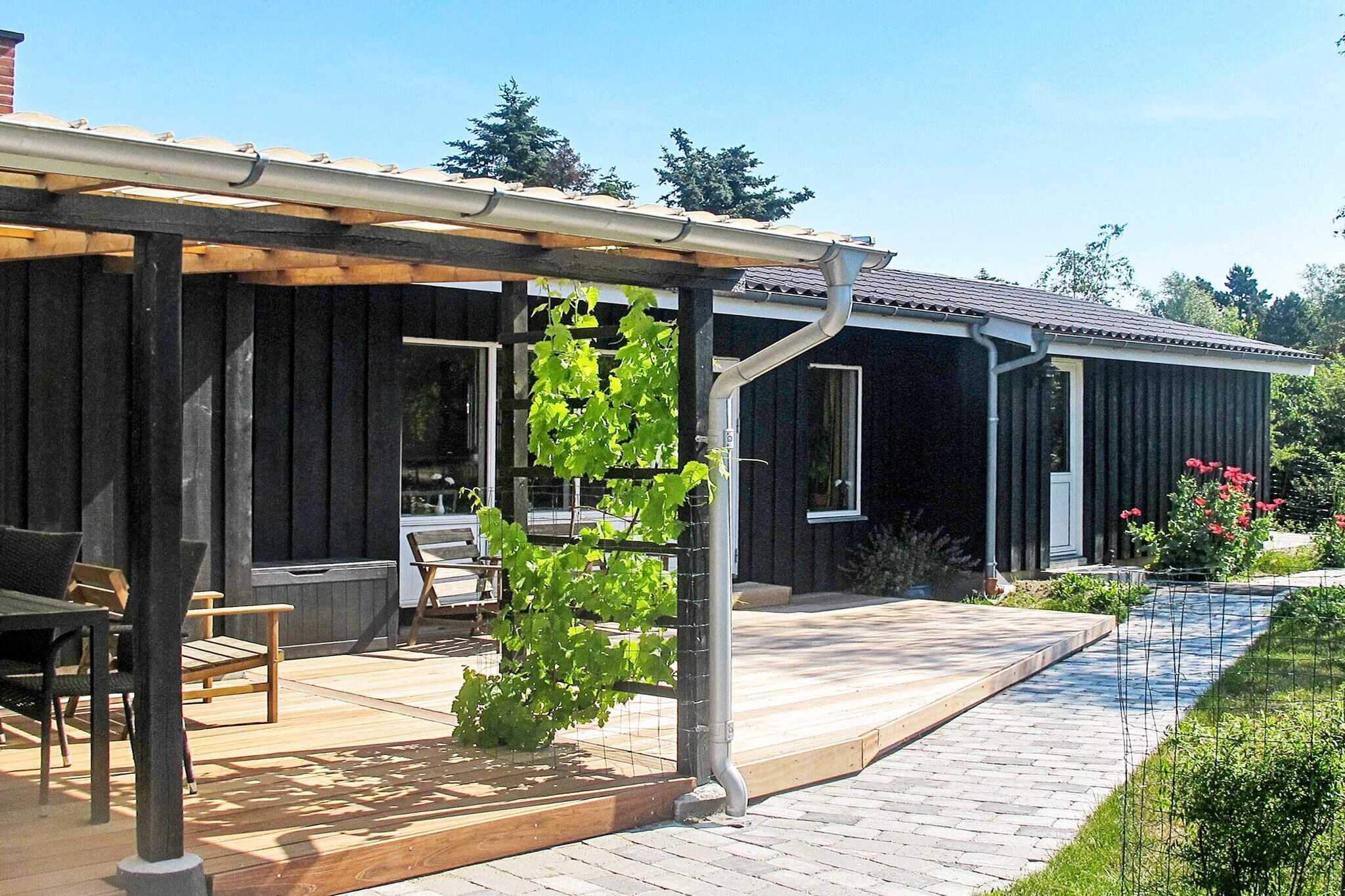 open kitchen(cooker(electric), hood, coffee machine, microwave, dishwasher, fridge, freezer(60-99L)), Living/bed room(TV(satellite, german television channels, danish TV channels (DR1 and TV2)), radio, high chair), bedroom(double bed, children\'s bed), bedroom(double bed), bedroom(double bed), bathroom(washbasin, shower, toilet, washing machine), heating(electric), terrace, garden, BBQ