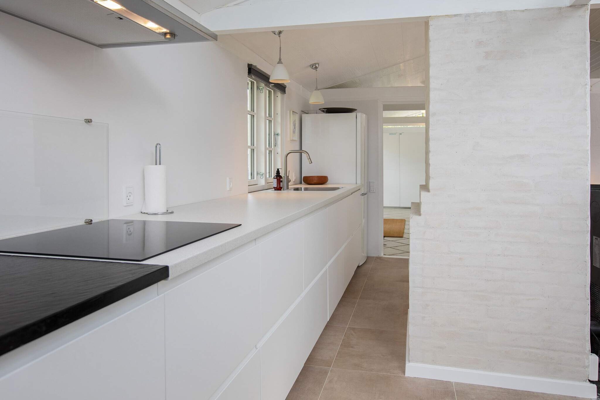 In probably the most coveted area in StrÃ¸by Ladeplads is this very exciting holiday home. The house is from 1986, and extensively rebuilt / renovated in 2020 and 2021. There are 124 m2 with an annex and activity room. In addition, a wonderfully enclosed and completely secluded terrace / patio. The house itself is newly painted and consists of a new kitchen in an open environment together with a dining area and living room. From there direct access to patio and sun terrace. Furthermore, hallway, bathroom and two bedrooms each with two beds. Built together with the main house and which is also adjacent to the courtyard, there is a large, exciting activity room, where you can have fun with, among other things. darts and table tennis. Next to the main house is the annex, which consists of a TV room with sofa bed and at the end of the living room there is a double bed. Furthermore, bathroom and kitchen with i.a. fridge / freezer. The annex has an independent cozy terrace. Well-laid and lovely secluded landscaped plot of almost 1,200 m2 and with only approx. 300m to the water. Turn on the grill and enjoy the sun and the silence. Not for rent to youth groups.