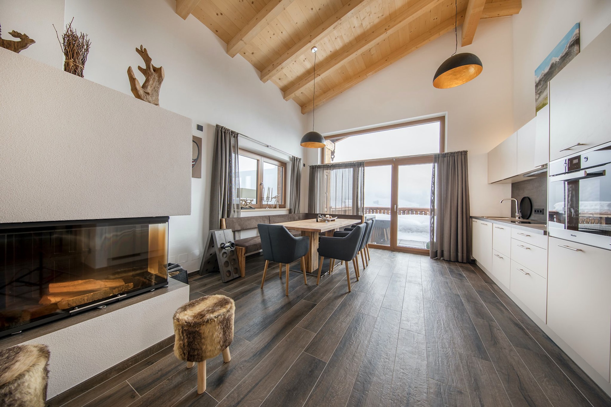 This detached chalet is located on the edge of the village of Neukirchen and offers a magnificent view of the Großvenediger, the highest mountaintop of the Hohe Tauern area. It is part of the Nationalpark Chalets and is named after one of the peaks of this nature reserve. In this luxuriously furnished chalet, you can accommodate up to four people for a comfortable holiday. There are two bedrooms with two bathrooms. The living room has a spacious sitting area and an open kitchen with dining area. The glass front not only offers a beautiful view of the mountain landscape but also provides access to the large balcony/terrace. Unwind in the sauna. In winter, ski directly from the reception area down towards the ski bus that takes you to the gondola of the Wildkogel Arena for a whole day of winter sports fun. If you want to visit another ski area, it’s just a 15-30 minutes' drive until you arrive at the Kitzbüheler Alpen or the Zillertal Arena. After an active day in the snow, you can enjoy all the luxury and comfort of Chalet Wildenkogel. Relax your muscles in the sauna and unwind in front of the cosy fireplace after the adventures of the day. In summer, the 'Nationalpark Sommercard' is included in your stay and allows you to take part in various free summer activities, among other things! You can use the ski lift once a day, free of charge, to take you to the top of the mountain. The children can enjoy themselves here in the playground, and various walking, cycling and mountain bike trails have been mapped out. Pay a visit to the Blausee, take the Pinzgauer Lokalbahn to visit one of the surrounding villages, take a day trip to Zell am See or simply enjoy the beautiful views from the spacious balcony/terrace of Chalet Wildenkogel.