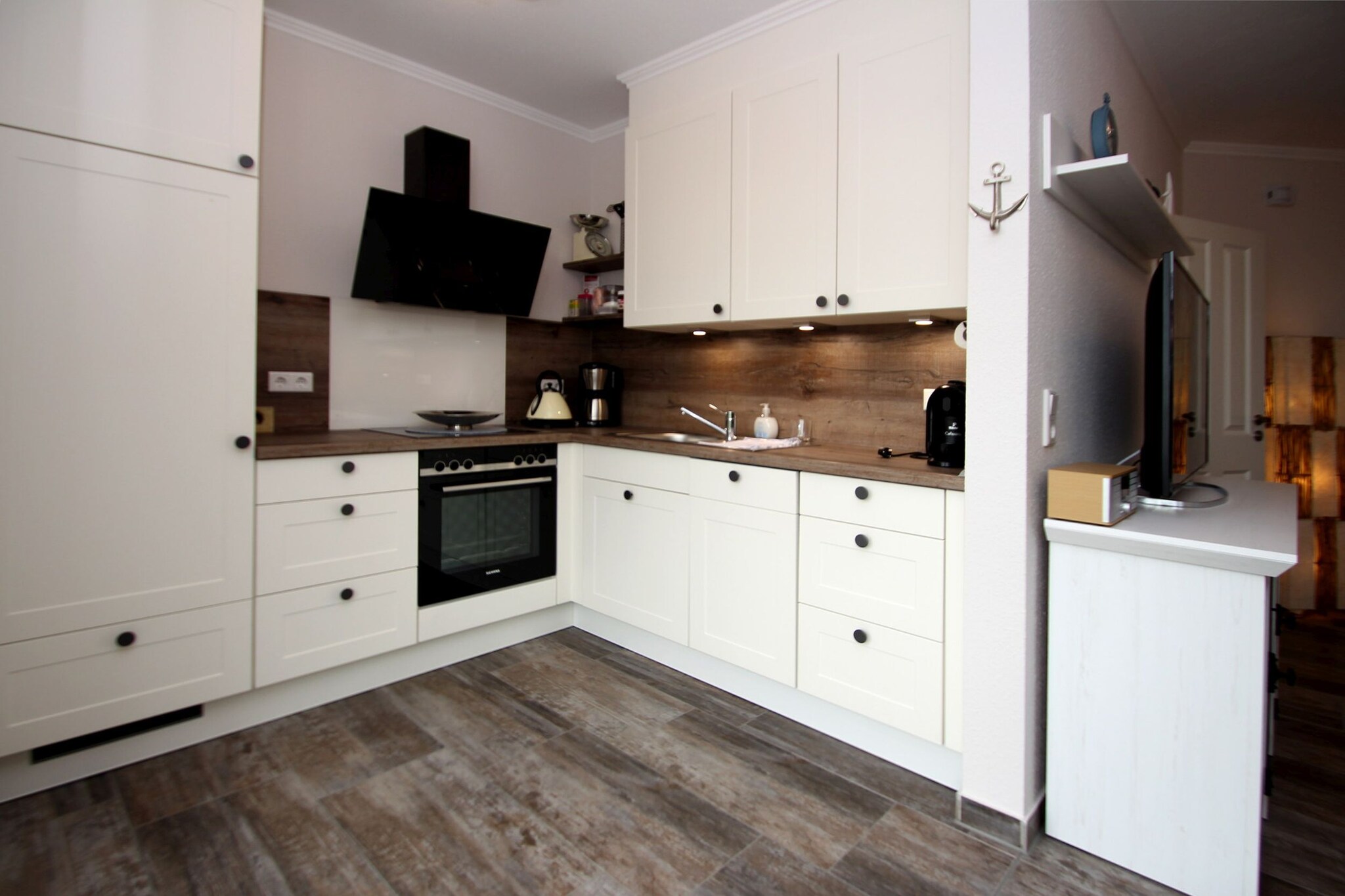 Ground floor: (open kitchen(stove, coffee machine(filter), oven, microwave, fridge-freezer, Hand blender), Living/diningroom(TV(flatscreen), seating area, radio), bedroom(double bed(boxspring), TV(flatscreen)), bedroom(single trundle bed(160 x 200 cm)), bathroom(shower, washbasin, toilet))\n\ngrill, washing machine, terrace, garden furniture, parking, high chair, baby crib(free)