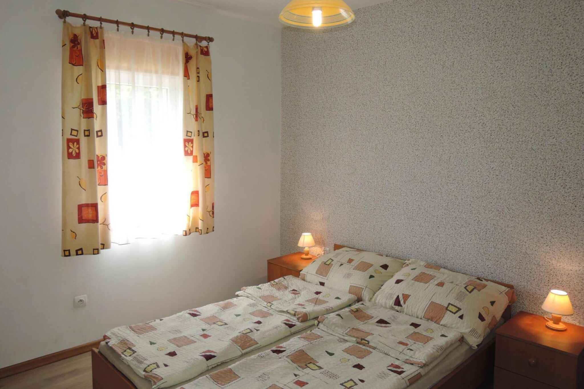 Ground floor: (open kitchen(electric kettle, cooker(2 ring stoves, electric), coffee machine, grill, microwave, fridge-freezer), Living/bed room(double sofa bed, TV(satellite, german television channels), dining table), bedroom(double bed), bedroom(single bed, single bed), bathroom(shower, washbasin, toilet))\n\nterrace(roofed), garden, garden furniture, parking lot(public), slide, high chair, Swing set, baby crib(free)