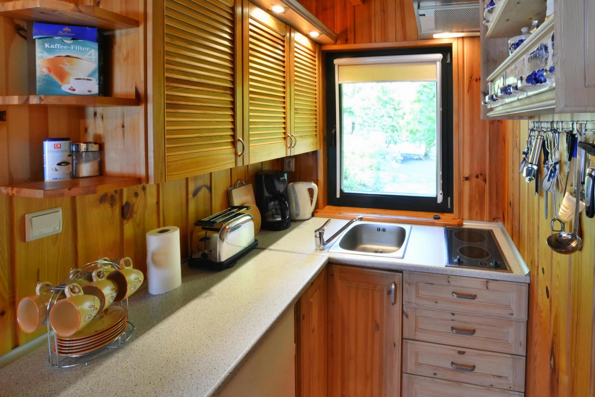 Ground floor: (open kitchen(electric kettle, toaster, cooker(2 ring stoves, ceramic), coffee machine, fridge-freezer), Living/diningroom(TV(satellite, german television channels), dining table), bedroom(2x single bed), bedroom(2x single bed), bathroom(shower, washbasin, toilet))\n\nAttic: (Gallery bedroom(single bed, single bed))\n\nbalcony, terrace(roofed), garden(shared with the owner , fenced, 300 m2), garden furniture, sun loungers, BBQ(charcoal), parking, trampoline, Garden shed