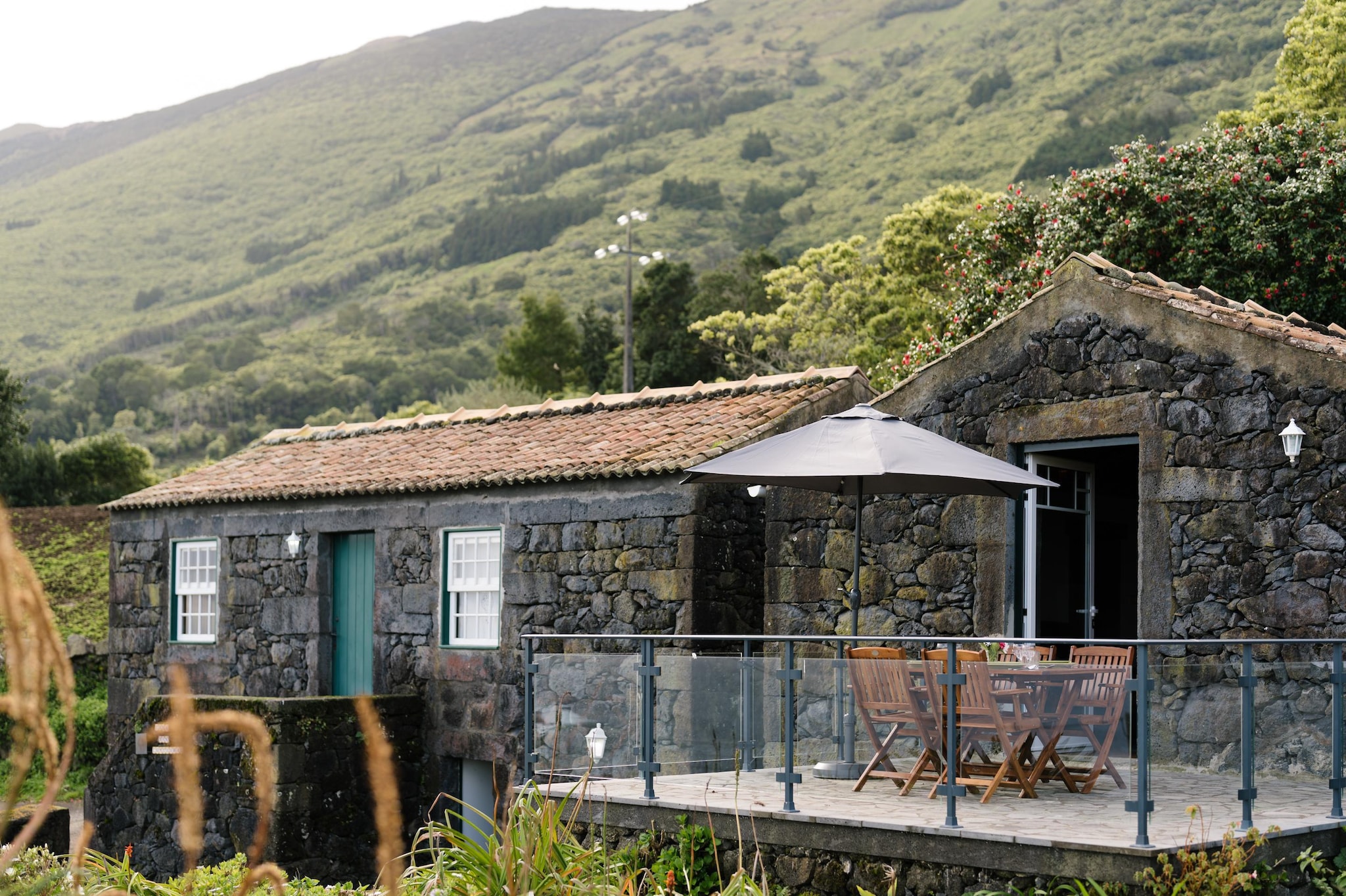 A paradise for nature lovers: rustic stone houses of various sizes, comfortably furnished in the style typical of the region, on the north coast of the island of Pico in a rural setting, twelve kilometers from the town of São Roque. Each of the restored houses has a panoramic view, including towards the neighboring island of São Jorge (some even have a sea view). A small beach is about 500 meters away, depending on the location of the house; Depending on the location, a natural swimming pool is about one to two kilometers away. The second largest island in the Azores owes its name to the Pico volcano of the same name, which is almost 2,400 meters high. The island is also known for its vineyards, its impressive landscape with lava fields and as a starting point for excursions to watch whales and dolphins.
Activities nearby : The island of Pico offers a wide range of leisure activities: go hiking along the coast, ride a bike or discover the green island on horseback. The natural swimming pools of PoÇa Branca are about 1.5 kilometers away. You can go whale and dolphin watching from Madalena Port or embark on an island tour to Faial. If you prefer to take it easy, you can relax at Praia do Canto da Areia beach. In the high season, activities such as traditional fishing or in-house cheese production are sometimes offered on site.