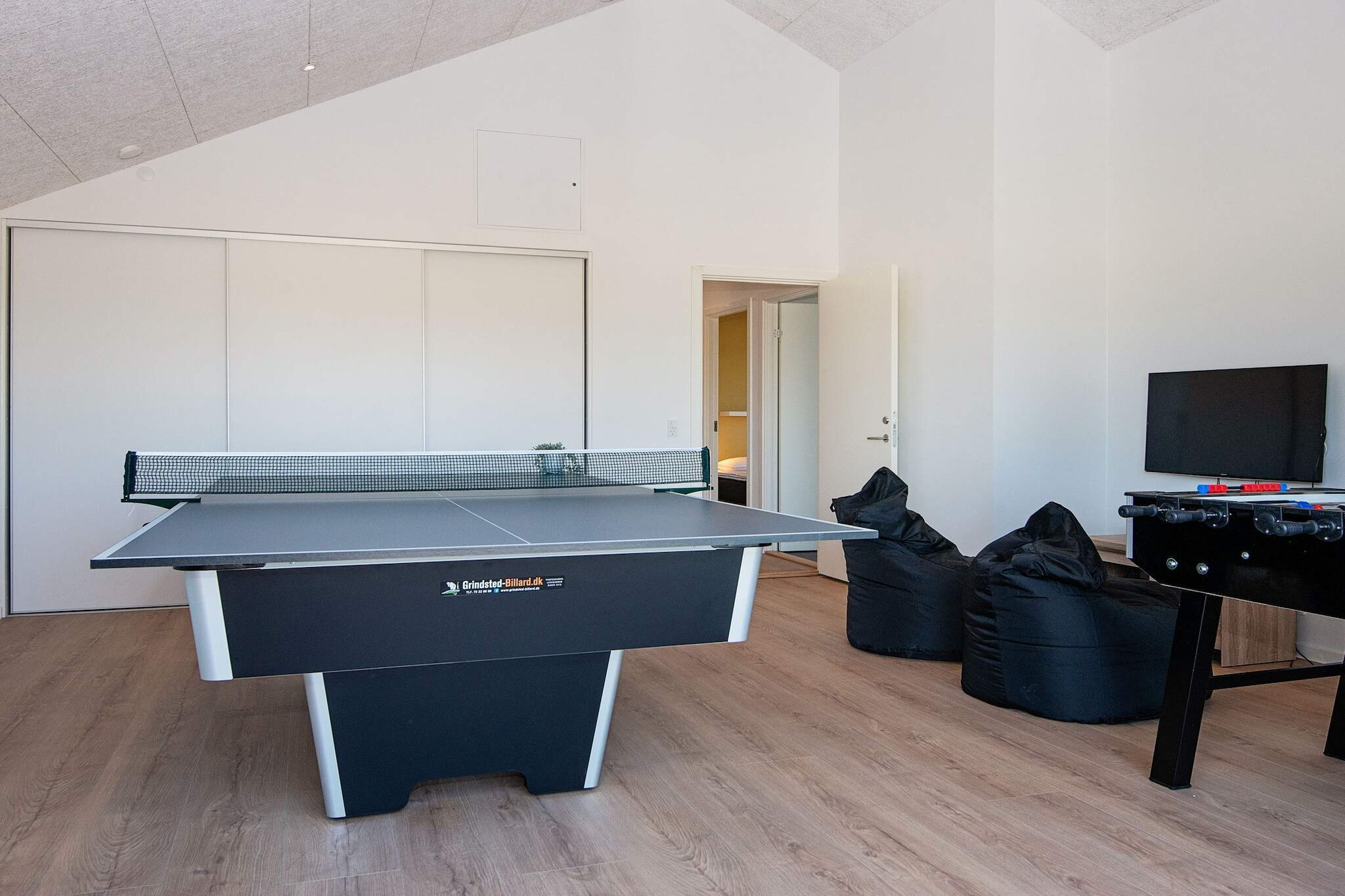 At Kvie Sø you will find this architect-designed summer house with an outdoor hot tub and plenty of room for 10 people + 2 people in the loft. In the house, emphasis has been placed on energy-efficient solutions with solar cells and 2 pcs. air/air heat pumps which can also be used as air conditioning. There is a cot in the house. Large, delicious outdoor hot tub for 6 people for comfort and relaxation in all kinds of weather and outdoor shower. The summer house has everything for the perfect summer house holiday with activities both outside and inside. In the activity room, you can play billiards, table tennis, table football or challenge each other in a game on the games console. There is a wooden terrace/walkway around the entire house and on the lawn there is an opportunity to jump on a trampoline and play a football match against a goal. There is free access to the Varde Swimming pool and partly also bowling. From the house there is only approx. 300 m to Kvie Sø, where you will also find the "pancake house" and the beautiful nature around the lake. The house is equipped with solar cells, which means that the electricity consumption that must be settled for is significantly reduced. It is possible to charge an electric car type CEE-kontakt IEC-60309. Not for rent to youth groups. No pets allowed.A refundable deposit might be charged closer to your check-in date. The security deposit ensures a smooth stay and covers any additional services or consumption charges.This deposit covers utilities consumed during your stay and any additional services that may be taken.The final amount will be adjusted based on actual meter readings, actual usage of extra services, and any remaining balance will be refunded within 21 days after checkout.This deposit simply acts as a prepayment for charges that you would anyways pay for, ensuring a seamless stay and check-out experience.