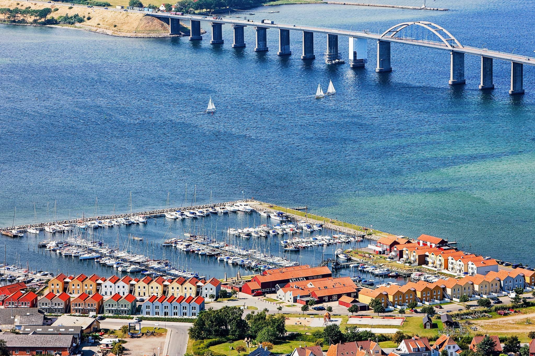 This charming terraced holiday home offers a unique stay directly on the marina, just five meters from the sea and within walking distance of the historic sailing town of Rudkøbing. Here, the gentle sounds of the water and the sight of moored sailboats create a peaceful coastal atmosphere, perfect for a relaxing getaway. The surrounding area offers plenty of activities and conveniences, including restaurants, bars, a playground, sports courts, and a petanque pitch, making it an ideal choice for both relaxation and recreation.
The house is simply yet thoughtfully furnished, with comfort and functionality in mind. Its standout feature is the pair of terraces, one at the front and one at the back, ensuring you can enjoy sunshine or shelter at any time of day. From here, you’ll have a beautiful view of the Langelandsbroen Bridge, the bustling marina, and the neighboring islands of Siø and Tåsinge, offering a true sense of being immersed in Denmark’s scenic coastal charm.
Whether you’re sipping morning coffee while watching the harbor wake up or enjoying a glass of wine as the sun sets over the sea, this home’s location provides a perfect backdrop for a memorable holiday. With the lively yet charming harbor right at your doorstep and the cultural attractions of Rudkøbing nearby, it’s easy to balance peaceful seaside moments with vibrant local experiences. This home is an inviting base for couples or families looking for a cozy, well-located retreat by the water.