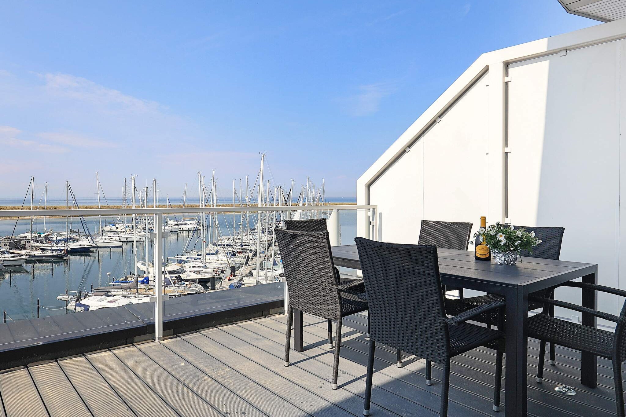 Located right on the harbour front of Marina Wendtorf, this penthouse apartment feels like a little escape by the sea. Step inside and you’re greeted by light-filled interiors and a living space that opens directly onto a spacious roof terrace. Here, mornings begin with coffee overlooking sailboats drifting out to the Baltic, and evenings are best spent with a glass in hand as the sun sets over the harbour. The panoramic views, both from the terrace and through the large living room windows, make the sea feel like part of the home. The apartment itself is modern and warmly inviting, thoughtfully designed for both comfort and style. The open-plan kitchen and living area make gatherings easy, with everything from a stove and WOK hob for cooking to a bioethanol fireplace for cosy nights in. Two comfortable bedrooms with double beds and flat-screen TVs ensure restful nights, while an extra sofa bed offers flexibility for families or friends. A sleek bathroom with a rain shower, steam bath function, and underfloor heating adds a touch of spa-like luxury. Entertainment is always within reach with a soundbar, Bluetooth connection, Blu-Ray player, and even binoculars available from the service office for spotting ships on the horizon. Life here blends relaxation with activity. Little guests will love the playgrounds on the promenade and the fun of the activity centre with slides, climbing, and even a black-light mini golf course—all included for guests. With a lift for easy access, private parking, and restaurants just steps away, this harbour-view penthouse is the perfect balance of comfort, convenience, and unforgettable sea views.A refundable deposit might be charged closer to your check-in date. The security deposit ensures a smooth stay and covers any additional services or consumption charges.This deposit covers utilities consumed during your stay and any additional services that may be taken.The final amount will be adjusted based on actual meter readings, actual usage of extra services, and any remaining balance will be refunded within 21 days after checkout.This deposit simply acts as a prepayment for charges that  you would anyways pay for, ensuring a seamless stay and check-out experience.
