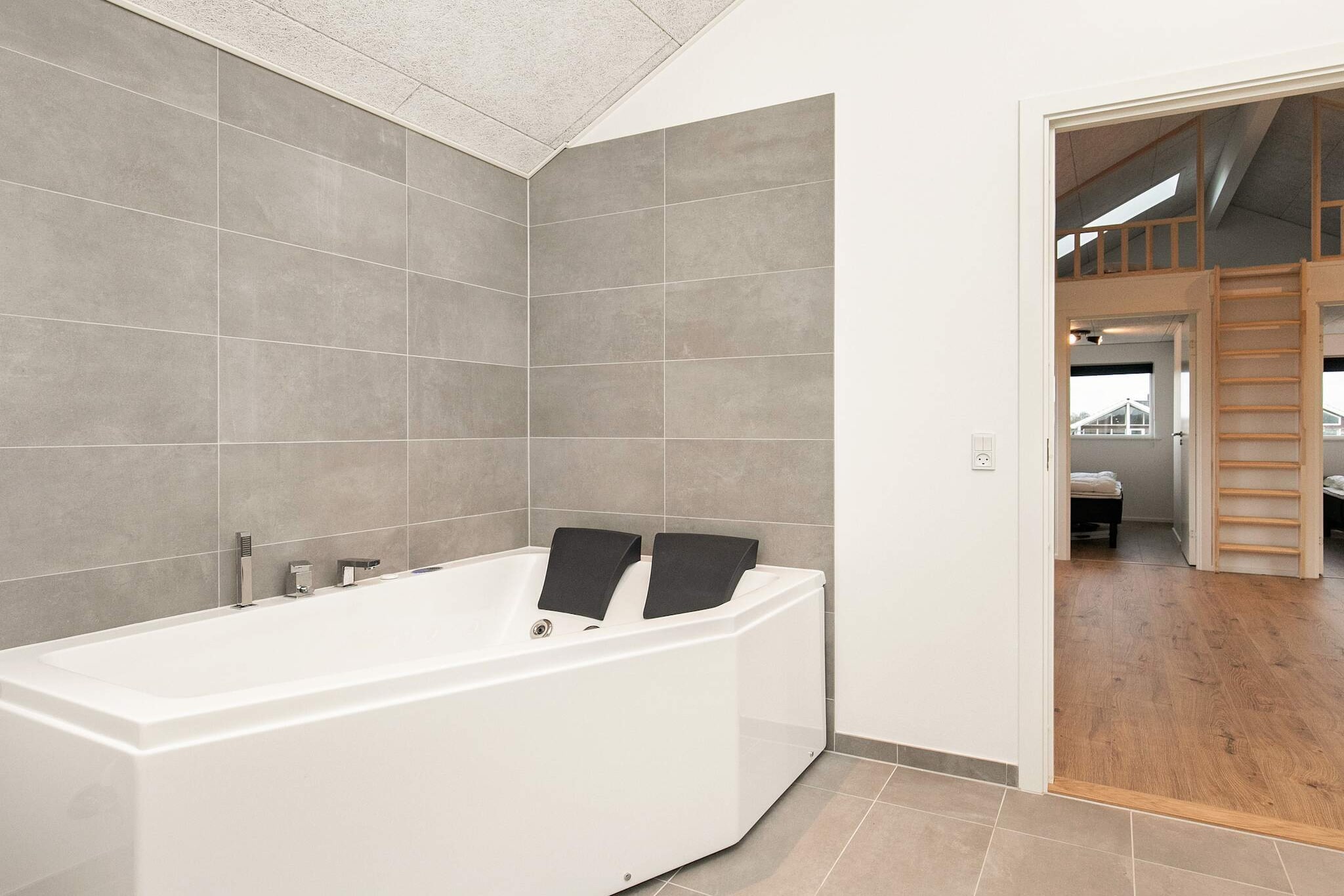 This spacious holiday home offers the perfect combination of comfort, modern amenities, and plenty of opportunities for relaxation and fun. Located not far from the popular Skåstrup Beach, guests can enjoy excellent swimming and fishing conditions or simply spend leisurely days by the sea. The property is also equipped with both an indoor and an outdoor whirlpool, ideal for relaxing moments as well as shared family enjoyment.
Inside, the house features a well-thought-out layout, making it especially suitable for families or groups of friends. Four bedrooms are furnished with double beds and high-quality box-spring mattresses, while a loft under the roof provides two additional sleeping spaces, perfect for children or teenagers. The bedrooms are divided into two separate sections, each with its own bathroom, ensuring privacy and comfort even for multi-family holidays. Both bathrooms are modern and equipped with underfloor heating.
The open-plan dining and living area is tastefully decorated, featuring a cozy sofa corner, flat-screen TV, Wi-Fi, and a wood-burning stove that adds a warm and inviting atmosphere. The modern kitchen is fully equipped, making it easy to prepare meals together. On cooler days, the combination of the wood stove and an energy-efficient air-to-water heat pump ensures a pleasant indoor climate. Outdoors, you will find not only the inviting whirlpool but also terrace areas perfect for lounging and enjoying sunny days. This makes the holiday home an ideal setting for a memorable and comfortable stay.
No rental to youth groups allowed.