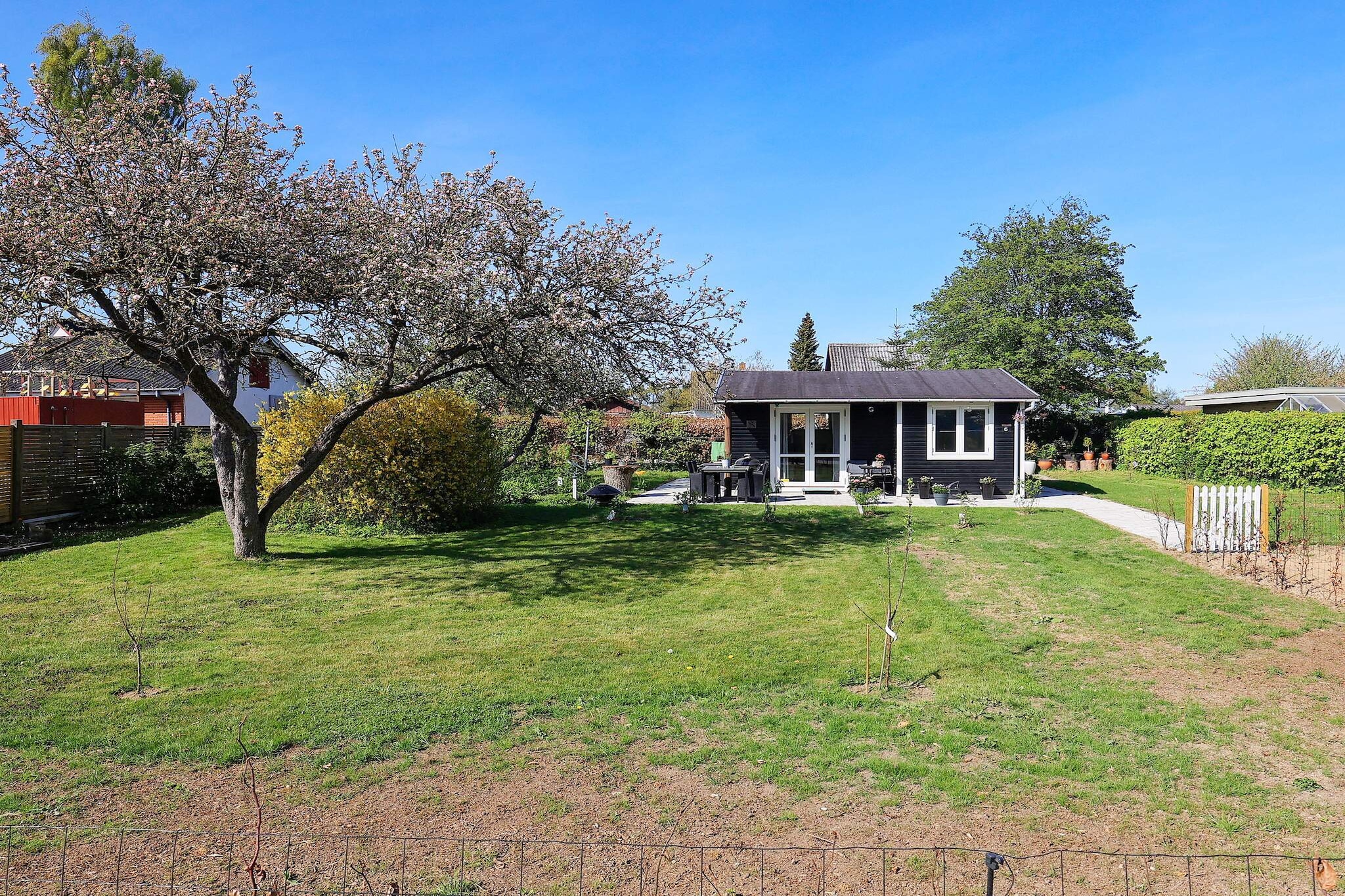 Just 100 meters from the water, this charming and well-maintained holiday cottage in Faxe Ladeplads offers a cozy retreat in a scenic location. Renovated in 2021 with new windows, the cottage combines comfort and simplicity, making it an ideal choice for small families or couples seeking a relaxing getaway near the coast. Inside, the living area is warm and inviting, featuring a TV and direct access to the terrace where you can enjoy sunny mornings or peaceful evenings. The cottage has one bedroom with two beds and a sofa bed in the living room, providing flexible sleeping arrangements for up to four guests. The kitchen, while modestly equipped, allows for simple meal preparation, and a bathroom completes the functional interior. Outside, a beautifully landscaped garden surrounds the house, offering a private space for play or relaxation. The property is just a short walk from a very child-friendly sandy beach, as well as the local marina, town center, and restaurants. For those seeking active adventures, the popular Feddet recreational area is nearby, perfect for hiking, swimming, and outdoor fun. With its cozy interior, convenient location, and proximity to nature, this cottage is a delightful base for a memorable seaside holiday. No rental to youth groups allowed.