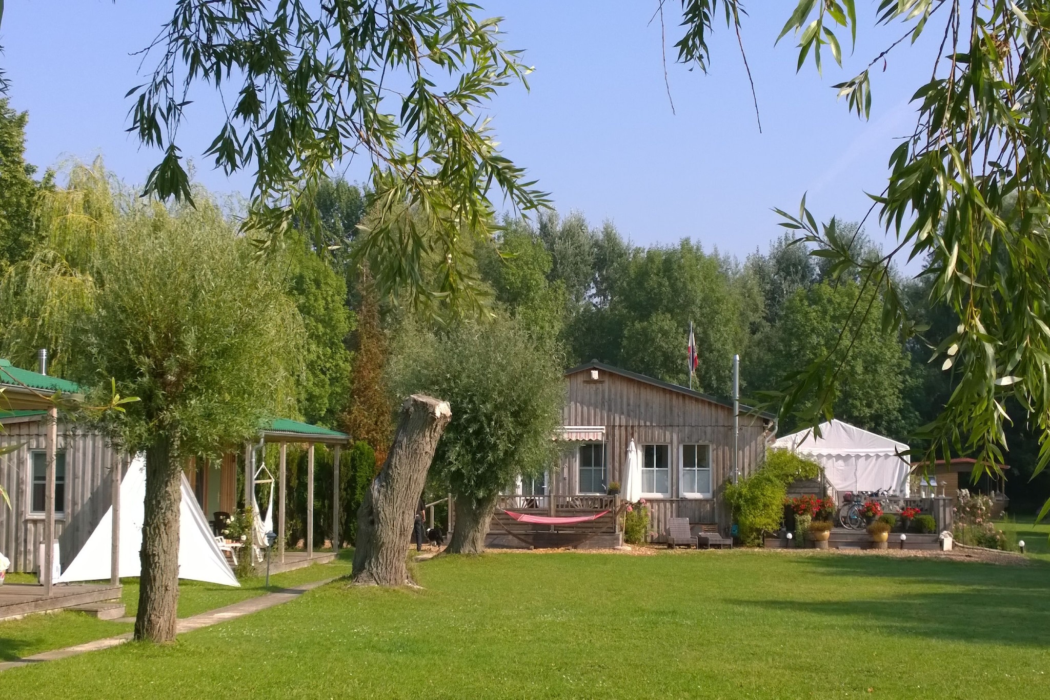 A family-run holiday village in a beautiful location directly on the Achterwasser lagoon on the idyllic Gnitz peninsula. Here, you can relax and unwind from everyday life at the jetty and on the private shore of this small complex – whether sunbathing, swimming, or taking a boat trip. The holiday homes are just 20 meters from the water and are modern and comfortably furnished, ensuring you feel right at home upon arrival. A covered terrace, Wi-Fi (for a fee), and some even feature a wood-burning stove, guarantee a relaxing holiday.

Lütow is situated on the Gnitz peninsula, nestled within the nature reserve of the Achterwasser lagoon. Here, you'll enjoy idyllic and romantic accommodations and have several worthwhile destinations nearby, such as the estate distillery in Neuendorf or the Neolithic megalithic tomb near Lütow. The long sandy beach of the Baltic Sea, stretching along the entire island of Usedom and into Poland, is also easily accessible.

Hiking and cycling tours through the stunning natural landscape of Usedom are also available. A beautiful day trip by bike is, for example, the circular route Gnitz Peninsula - Zinowitz - Trassenheide - Wolgast - Krummin - Gnitz Peninsula, which is about 55 kilometers long. You cycle through the middle of the island of Usedom, visit a beach, take a detour to the former residence town of the Pomeranian dukes, and then cycle back through the quiet hinterland of the Gnitz Peninsula.