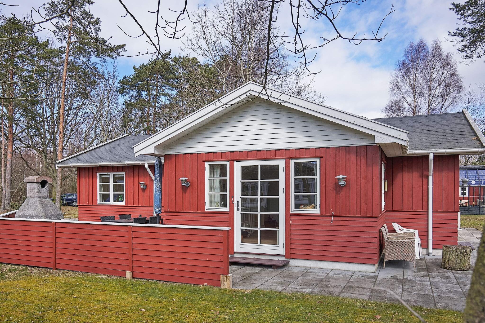 This holiday home is located in the peaceful cottage area of Sorthat-Muleby, just a short distance from the beautiful beach at Sorthat Rev. On the way to the beach, you pass through the forest, where you will encounter small man-made lakes and traces from the time when coal and clay were once mined in the area.
The house features a practical entrance and utility room with sink and washing machine. From here, you have access to a bathroom with a whirlpool tub, perfect for relaxing after an active day. The open kitchen and living area is the heart of the home, offering a bright, well-equipped kitchen, a dining corner, and a cozy lounge. A wood-burning stove and an energy-efficient heat pump provide warmth and comfort, while the large windows allow you to enjoy the surrounding nature.
From the living room, there are two exits to the spacious terrace that wraps around the entire house. Thanks to its design, you can always choose between sun or shade. The terrace is equipped with an outdoor shower and a stylish outdoor fireplace, making it an inviting space for relaxation. On the plot, you will also find a firepit for cozy evenings under the open sky. A parking space is available on the property.
Please note: rental to youth groups is not permitted.