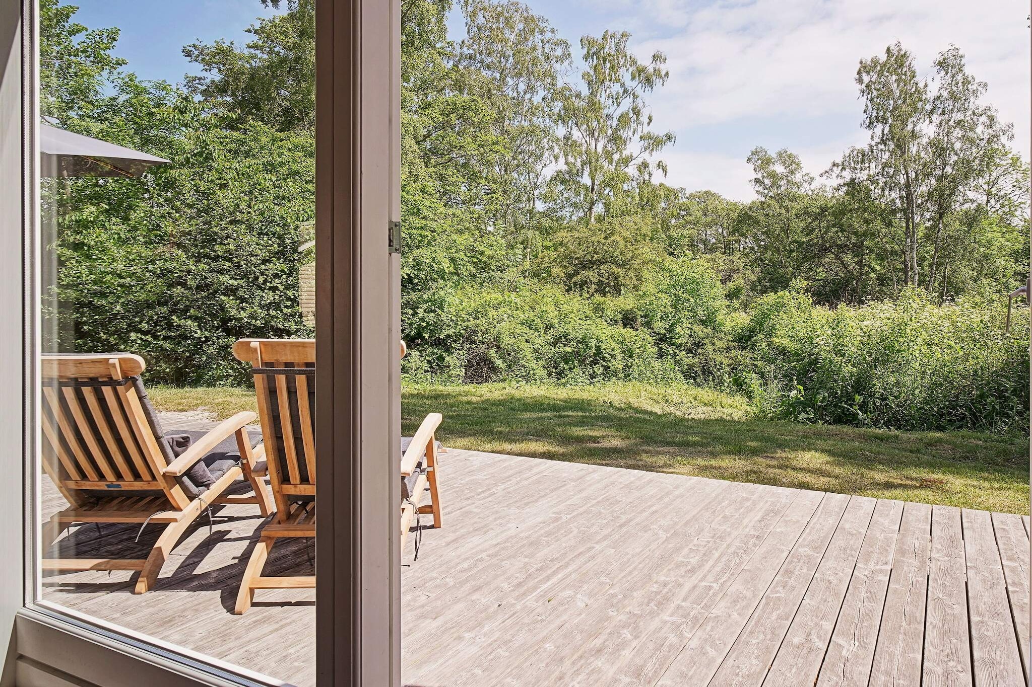 Near the beautiful sandy beach of Dueodde, this well-maintained and modernized holiday home offers a cozy and functional base for a relaxing or active getaway. The wooden house features a bright open-plan kitchen seamlessly connected to the dining and living area, complete with a wood-burning stove that creates a warm and inviting atmosphere. Inside, there are three comfortable bedrooms and a bathroom with underfloor heating, as well as a washing machine, dryer, and free Wi-Fi for convenience during your stay. Outside, a large terrace wraps around three sides of the house, providing lovely views over the surrounding greenery and natural landscape. The spacious plot includes a sandbox and plenty of room for children to play, while the nearby forest and cycling paths make it easy to enjoy long walks or bike rides. Just 400 meters from the water, the location is ideal for family days at the beach or exploring the natural surroundings. This part of Bornholm offers more than just sandy beaches. The 18-hole Dueodde Golf Course is only 1.6 km away, while the nearby town of Snogebæk has charming shops, restaurants, a fish smokehouse, and an ice cream parlor. Combining comfort, outdoor space, and access to both nature and local attractions, this holiday home provides an ideal setting for a memorable stay on the island. Please note: rental to youth groups is not permitted.