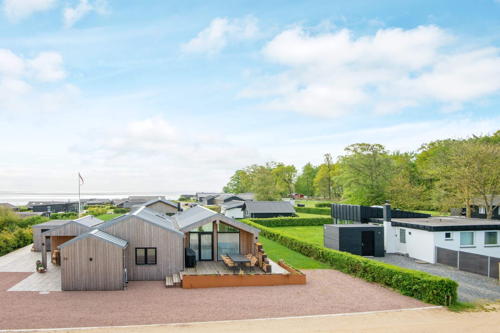 This vacation home near Kelstrup, not far from the German border, offers a very attractive setting for your next vacation on the Danish Baltic Sea coast! The house also offers beautiful views of the water in the Little Belt and the surrounding nature!
The centerpiece of the vacation home is the spacious kitchen/living area with an open ceiling up to the ridge and floor-to-ceiling windows for daylight and views. This room also provides access to the large terrace area with sea views. The large, bright rooms of the house contribute significantly to the feeling of well-being. There are also four bedrooms with comfortable beds.
After an active day outdoors or a long walk along the charming coastline, you can relax in the warm water of the hot tub in the evening. A practical outdoor shower is available for showering beforehand.
The modern amenities in the vacation home also include a dishwasher, washing machine, dryer, charger for electric cars, climate-friendly heat pump, free Wi-Fi, and TV with Chromecast for streaming your own providers.
Outside, the 130 m² of terrace space invites you to relax in the sun or shade, as around 15 m² of the terrace is covered. This means you can spend your vacation outdoors. A gas grill is available, and the owner has already provided a spare gas bottle. From June 21, 2025, a swing, sandpit, and table soccer will be available.
A day trip to the island of Årø is one of many possible excursion destinations. The island is known for its beautiful nature and also has a winery and the Ølbryghus brewery to offer. Or you can book a ferry trip to the small island of Barsø. You can also visit the UNESCO town of Christiansfeld or go shopping in Sønderborg.
No rentals to youth groups!