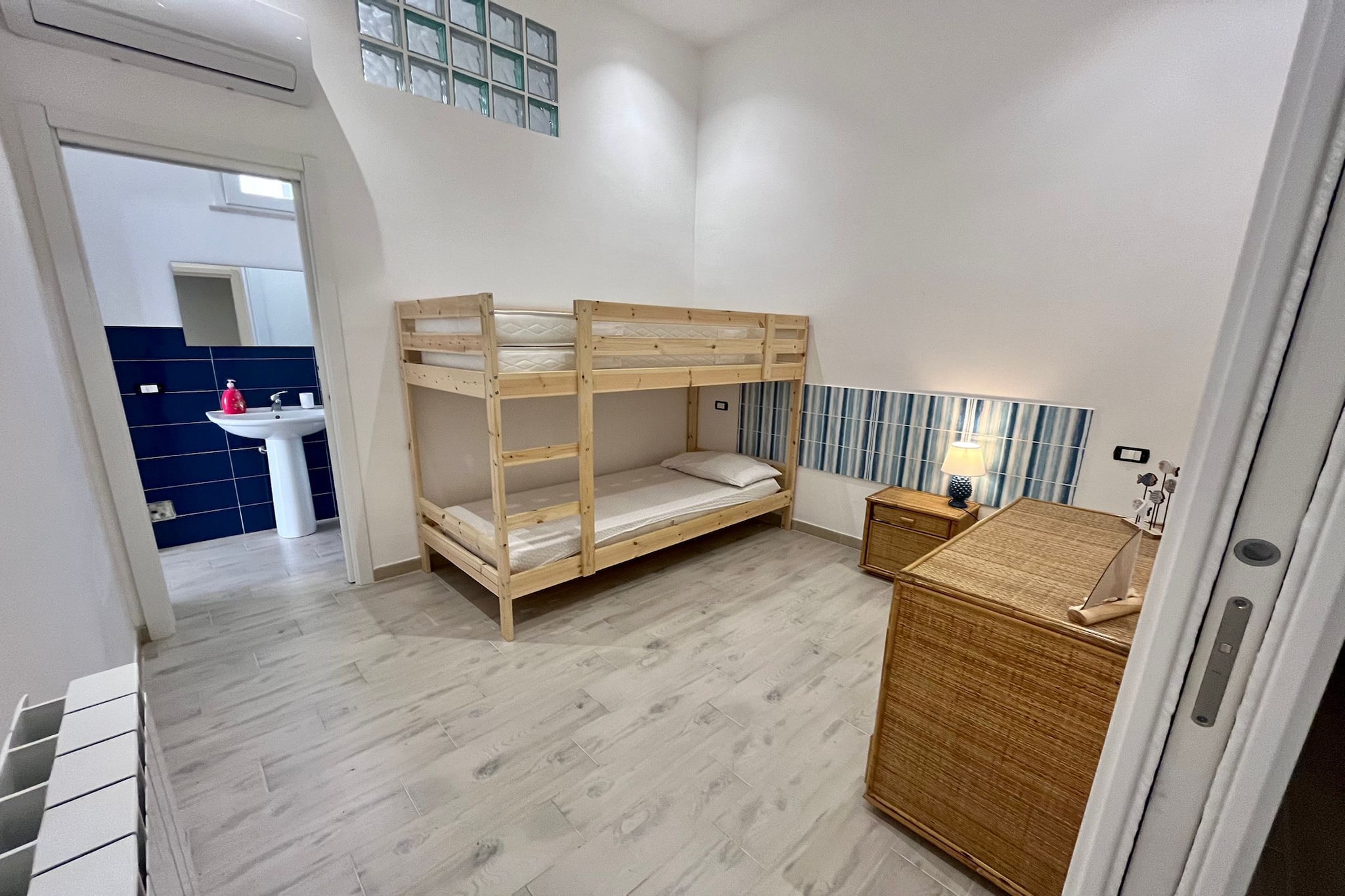 Ground floor: (Living room(double sofa bed, TV), Kitchen(dining table, coffee machine, fridge-freezer, washing machine), Bedroom with bathroom(bunk bed, shower, washbasin, toilet, bidet), Bedroom with bathroom(double bed, shower, washbasin, toilet, bidet))\n\nwashbasin, air conditioning, terrace, parking lot(public)