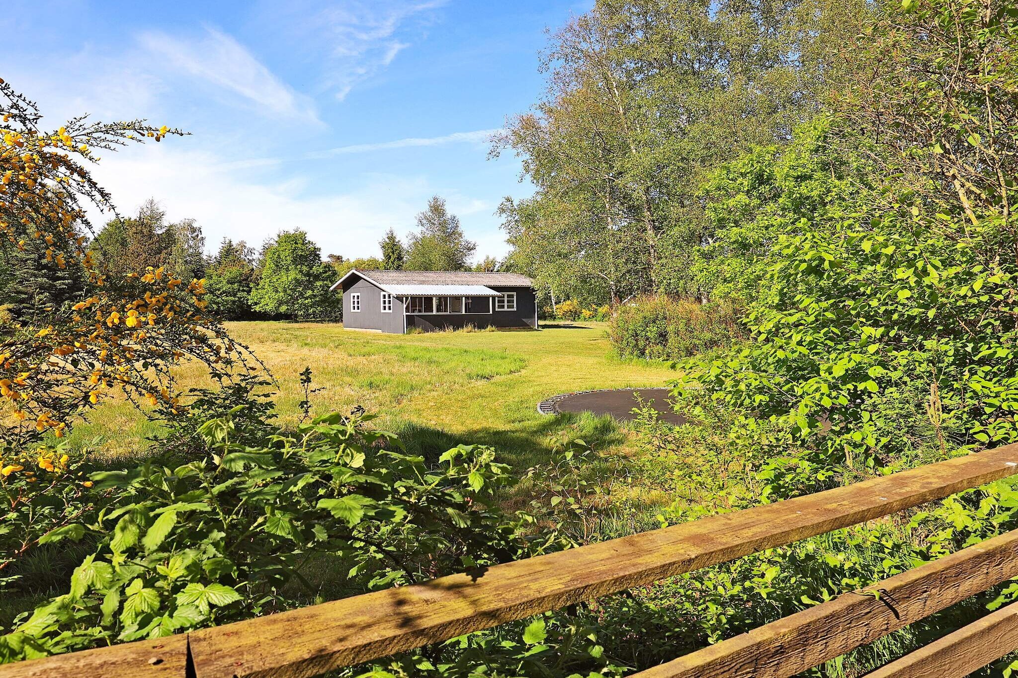 Cozy and atmospheric holiday home located just 300 meters from the fjord. The house is set on a private garden, providing ample opportunity to enjoy a peaceful and relaxing stay. Multiple outdoor corners are ideal for reading a good book while children play football or use the trampoline (use at your own risk). The house is thoughtfully arranged with an open-plan living, kitchen, and dining area. The living room features comfortable seating, free Wi-Fi, and a flat-screen TV with Chromecast, allowing you to stream your own TV services. The fully equipped kitchen includes a stove, extractor hood, microwave, coffee machine, and refrigerator. A high chair is available for the little ones. The bathroom is fitted with a shower, bathing area, and toilet. There are two bedrooms: one with a double bed and the second with a double bed plus two bunk beds, making it suitable for families. Outside, the covered terrace is furnished with garden furniture and a gas grill, perfect for enjoying dinner while watching the sunset. The property provides a great mix of indoor comfort and outdoor leisure in a tranquil setting close to the fjord. This holiday home offers an ideal base for a family vacation with opportunities for relaxation, play, and enjoying nature. Its location near the water and the well-designed outdoor spaces make it a perfect getaway for both children and adults. Please note: rental is not available to youth groups.A refundable deposit might be charged closer to your check-in date. The security deposit ensures a smooth stay and covers any additional services or consumption charges.This deposit covers utilities consumed during your stay and any additional services that may be taken.The final amount will be adjusted based on actual meter readings, actual usage of extra services, and any remaining balance will be refunded within 21 days after checkout.This deposit simply acts as a prepayment for charges that  you would anyways pay for, ensuring a seamless stay and check-out experience.