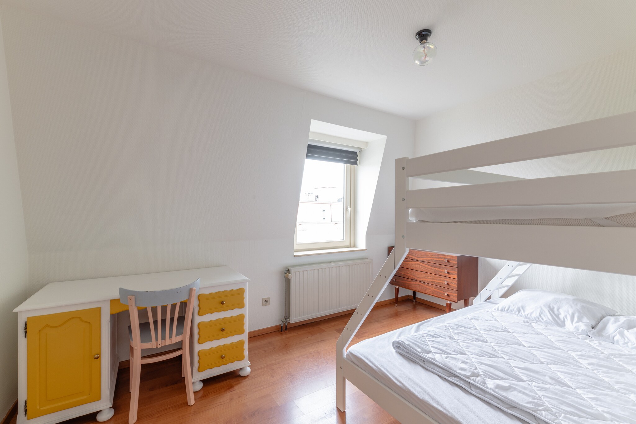 On the 3rd floor: (Kitchen(hob(ceramic), electric kettle, toaster, coffee machine, oven, microwave, dishwasher, fridge), Living/diningroom(TV(digital), dining table, seating area), bedroom(single bed, single bed), bedroom(3-person bunk bed), bathroom(bath tub, shower, washbasin), toilet(toilet))\n\nAttic: (bedroom(double bed))\n\nDVD player, high chair, ironing board, iron