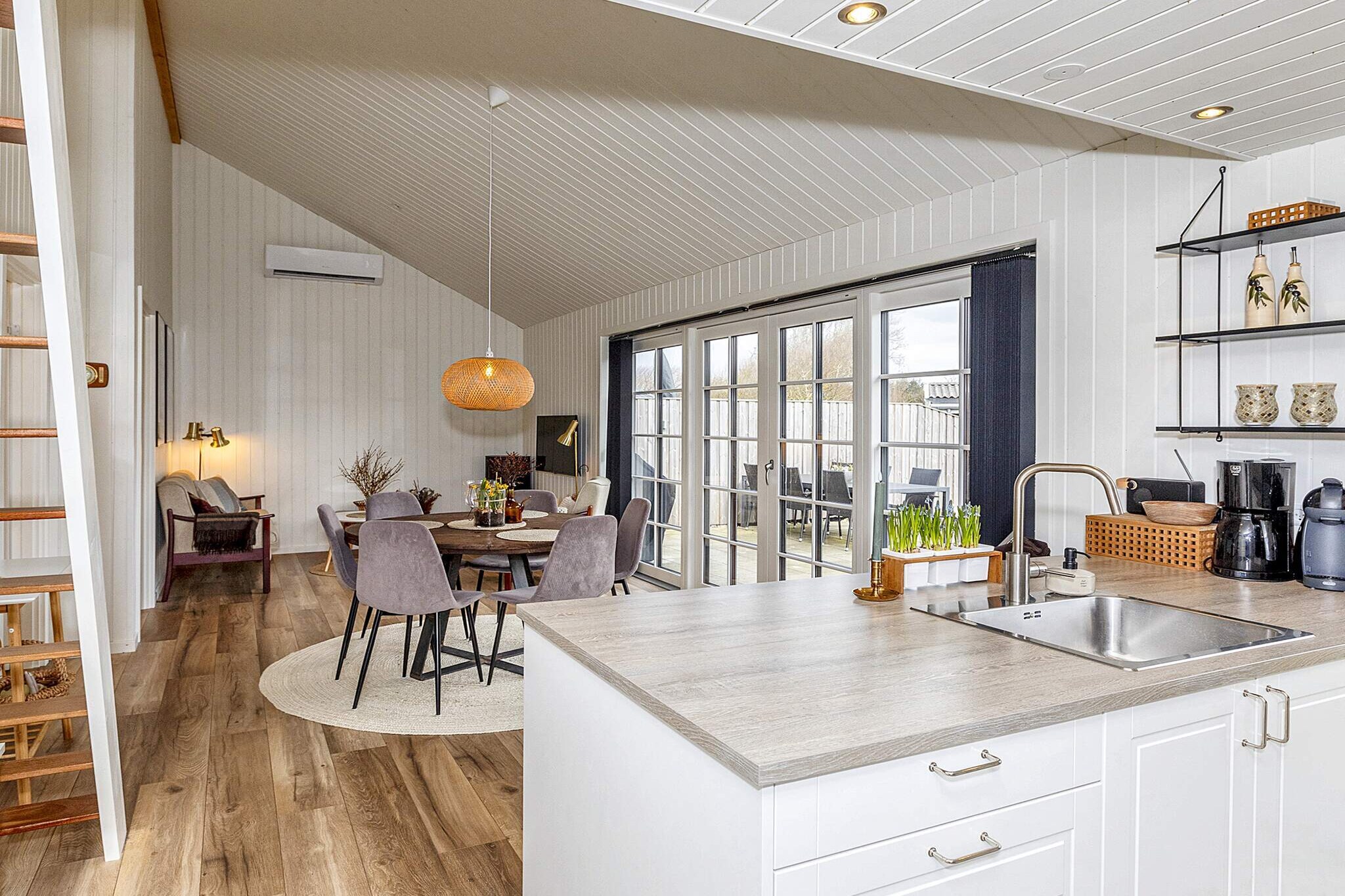 Kitchen(stove(2 ring stoves), cooker(2 ring stoves), coffee machine, oven, microwave, dishwasher, fridge-freezer), Living/bed room(TV, gas fireplace, chromecast), bedroom(double bed), bedroom(double bed), bathroom(washbasin, shower, toilet, washing machine), mezzanine(2x single folding bed), shower(outside), heating(electric), garden, garden furniture, air to air heatpump