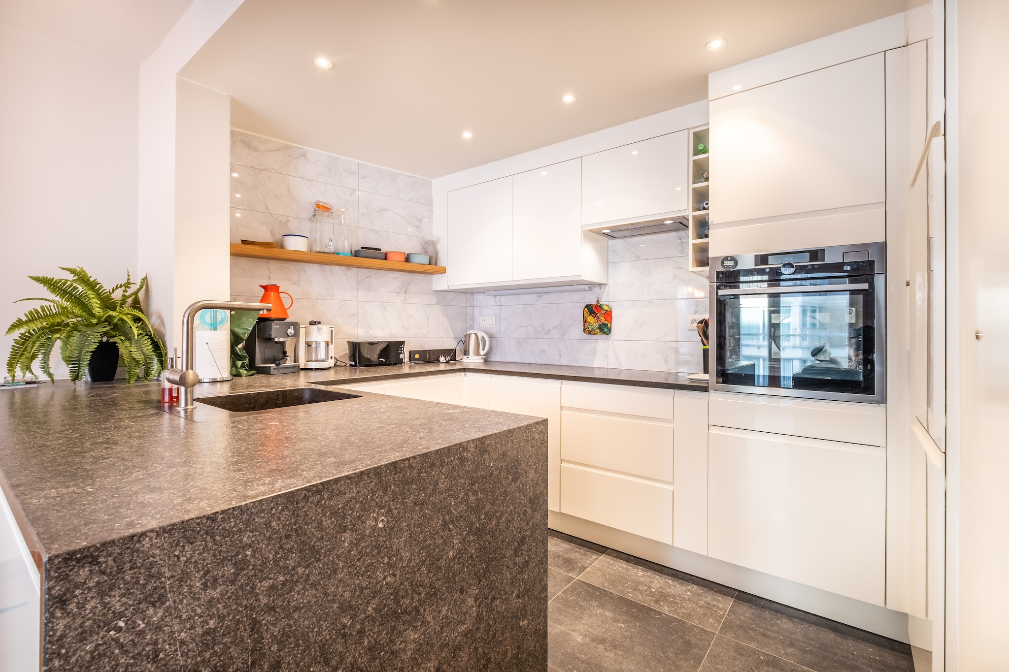 On the 3rd floor: (hallway, Kitchen(hob(induction), electric kettle, toaster, hood, coffee machine(pads), oven(steam), oven, microwave, dishwasher, fridge, freezer, Hand blender), Living/diningroom(TV(flatscreen, digital), dining table(6 persons), seating area), bedroom(single bed(duvet), single bed(duvet), washbasin), bedroom(single bed(duvet), single bed(duvet), washbasin), bedroom(single bed(duvet), single bed(duvet), washbasin), bathroom(tumble dryer, bathtub with shower, washbasin, washing machine), toilet(toilet))\n\nheating(central, gas), lift