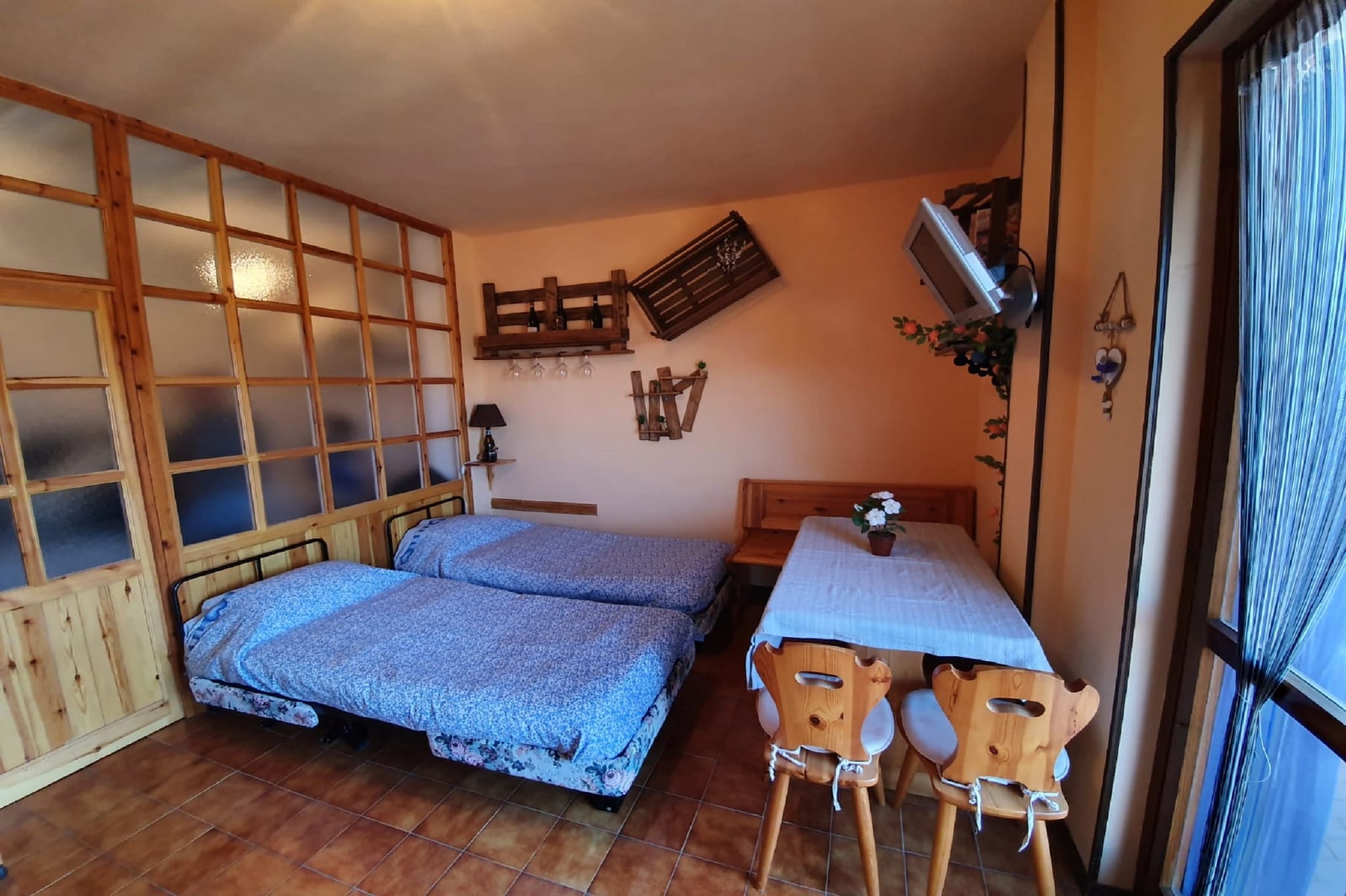 Ground floor: (open kitchen(hob, electric kettle, coffee machine, fridge, washbasin), Living/bed room(single bed, single bed, TV, dining table), bedroom(double folding bed), bathroom(shower, washbasin, toilet, bidet))\n\ndining table, balcony, parking, plancha grill