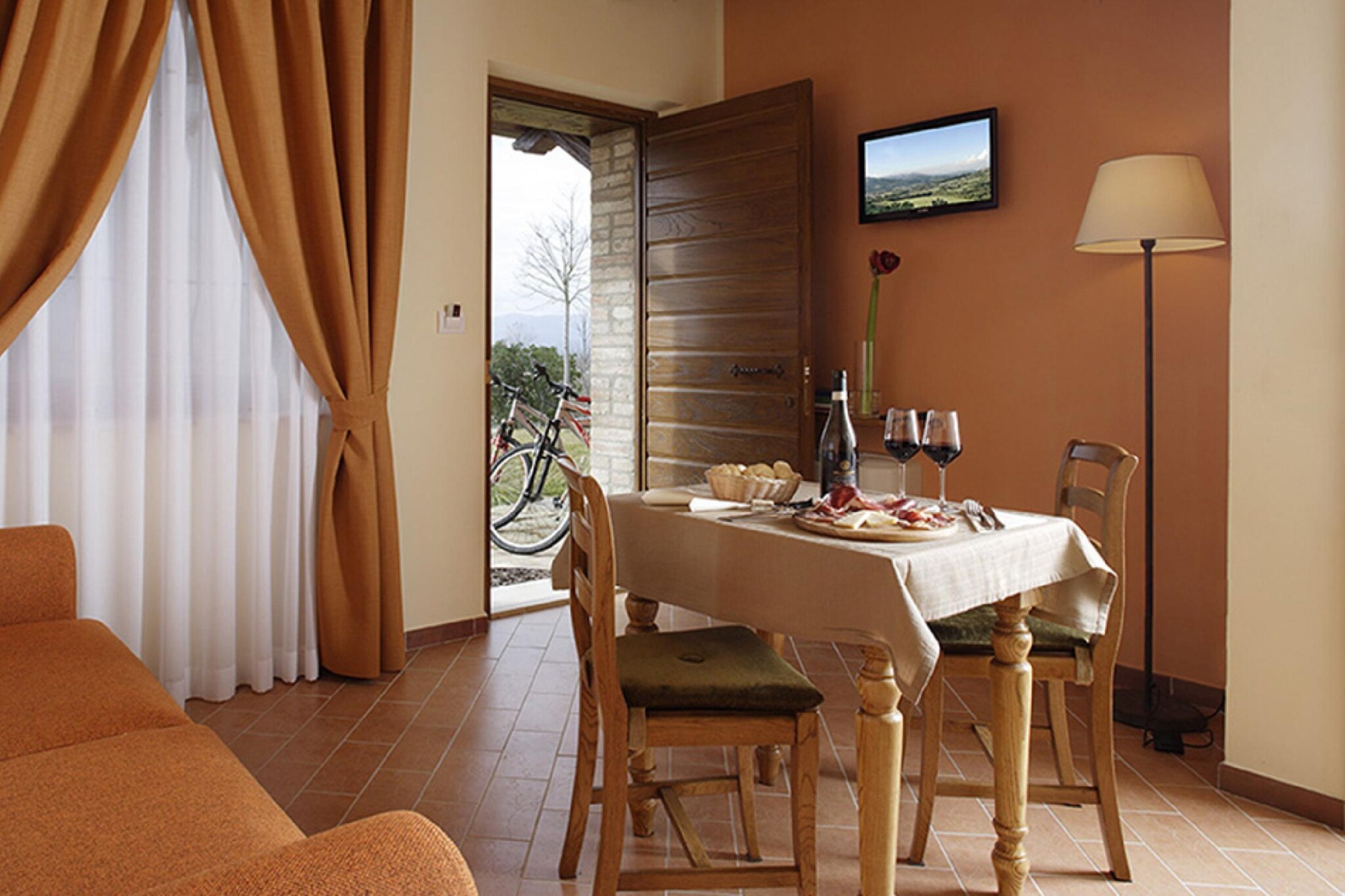 Holiday apartment on a farm in Umbria.
The farm is located in the green heart of Italy: Umbria, to be precise in Passage of Bettona, only 15 km away from Perugia and close to some of the most characteristic art cities of the region such as Assisi, Spello, Spoleto, Todi, Gubbio. The farm extends over 40 hectares, 10 of which are planted with olive groves and vineyards, the rest with arable land. The accommodation, recently built, is furnished with care and good taste down to the smallest detail.
It is enriched by a spectacular panorama that opens onto the valley from Perugia to Spoleto. From the windows facing Assisi, the alternation of morning mists, bright sun and fiery sunsets are able to give unique sensations.

Peace and relaxation will be the main ingredients that characterize an unforgettable holiday amidst the greenery, traditions, scents and pristine beauty of the characteristic Umbrian landscape. In the surrounding park, an enchanting salt water infinity pool built with natural stones, equipped with night lighting, will be able to create magical atmospheres on warm summer evenings. To frame the beautiful view of Assisi. The swimming pool is equipped with an independent professional hydromassage with water jets and blowers.

Wine and oil produced on the estate can be tasted on our table and purchased directly in the shop. The agritourism has a purely naturalistic area dedicated to farmyard animals. Typical restaurant with local, national and international products. The farmhouse can accommodate up to a maximum of 30/40 people.

This apartment:
is located on the ground floor 40 sq m. with access from the garden. In addition to the double bedroom which also has a sofa bed (for one person), in the other room there is another sofa bed (for two people).
Bathroom with shower located in the center of the apartment with an anteroom, so as to respect the privacy of the people who host the apartment.
The living area has a kitchenette. Independent entrance, Double bed, Single sofa bed, Closet, Writing desk,
Service corner with sink and electric hob, mini bar, sofa bed for two, table with chairs, safe, television, internet connection, heating, air conditioning, bathroom with shower cubicle, hairdryer.
Outdoor area/equipped garden.