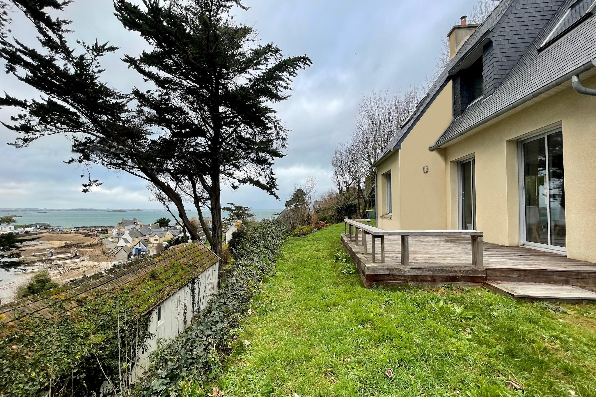 A top location and a fantastic view of the sea and the offshore coastal area offers this beautiful accommodation that leaves nothing to be desired. The 1,200 sqm garden plot is located above the harbour of Terenez, which can be reached via a small footpath.  Here you will not only find the first small bathing bay (400m), but also an excellent creperie, where you should definitely try the various delicious crepes and galette dishes. With its spacious living room, its cosy fireplace corner, its well-equipped kitchen, 3 bedrooms, 2 bathrooms and another small sleeping area, the holiday home offers excellent living comfort in all seasons. The garage can also be used for your car or to store bicycles. 

You can start the day with a refreshing swim on the small beach, get some oysters from the neighbourhood oyster farm for lunch, and in the evening admire a beautiful sunset from the terrace with a glass of Kir, the Breton aperitif. The eight beaches belonging to the municipality of Plougasnou are located at the eastern end of the bay of Morlaix and spread over 17 km of coastline. In the summer months, a tour of Morlaix Bay is offered from the small port of Le Diben. To the north, the beautiful pink granite coast beckons.
