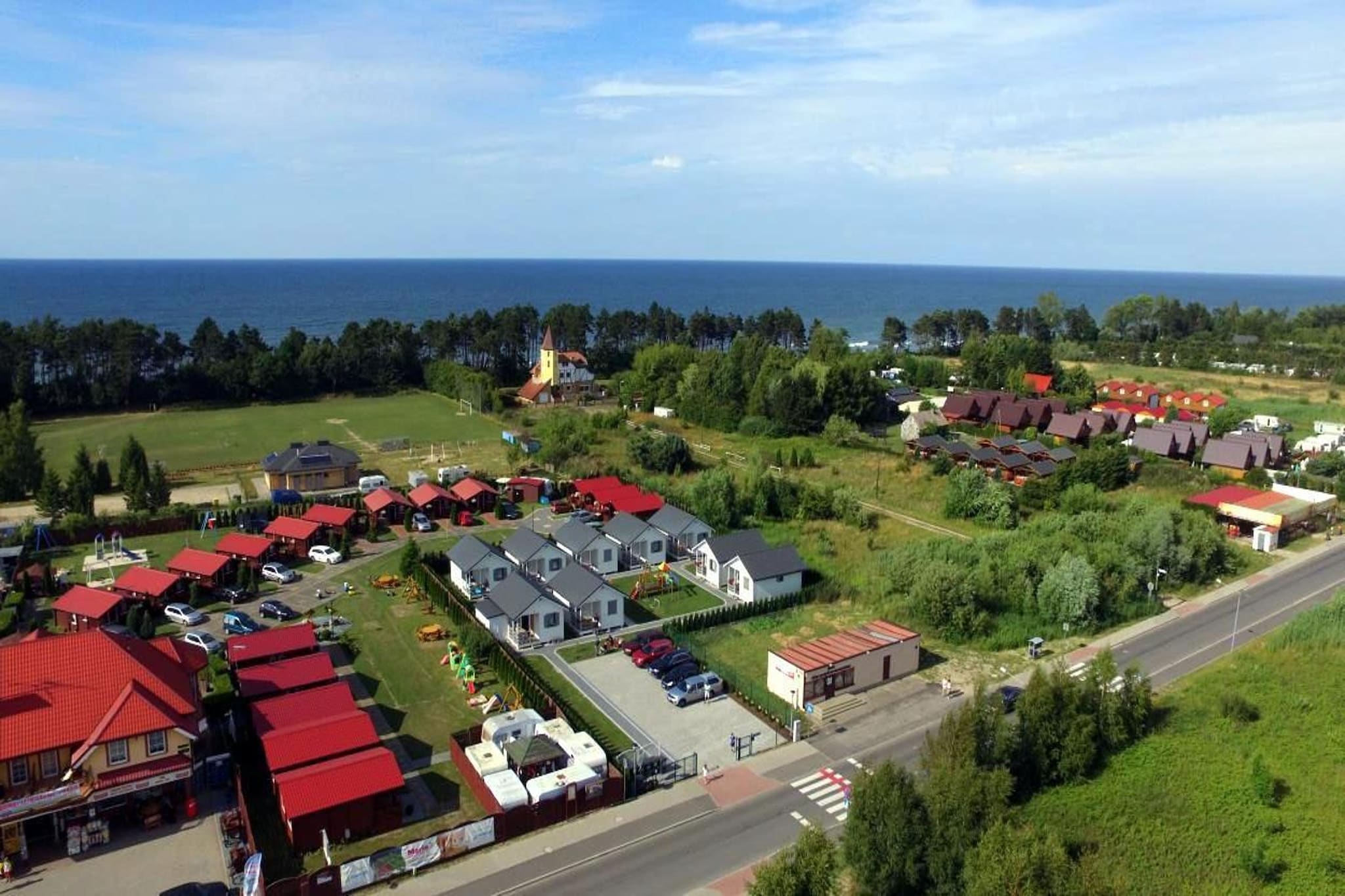 A family holiday resort, located 200 m from a beautiful seaside beach, in a small seaside settlement (GÄ…ski).
The comfortable one-story house has a covered terrace with a set of garden furniture. Inside there is a living room with a double sofa bed and TV, 2 separate bedrooms and a bathroom with a shower. The living room is connected to the kitchen. Electric heating is possible. Barbecue facilities are available. Wireless internet available.
The well-kept grounds of the center include a reception, a playground for children and a parking lot.
The price of the stay includes: bed linen, electricity and water consumption, final cleaning, internet, parking, baby cot and high chair (prior reservation required).
GÄ…ski is a small summer resort on the Baltic Sea, but in the season there are also many shops and bars. There are more restaurants and shops, also open outside the holiday season, in neighboring SarbinÃ³w. GÄ…ski is an ideal place for holidaymakers who want to take a break from the hustle and bustle of the city, who value peace and quiet, as well as for families with children.
The biggest attraction of GÄ…ski is the second largest lighthouse in Poland (51.2 m high). The lighthouse in GÄ…ski is open to visitors. From its top you can admire a beautiful panorama of the area.
Nearby attractions: The seaside strip around GÄ…ski is an ideal place not only for scenic walks, but also for longer bike rides. The Baltic Bicycle Route R-10 runs through here, which allows you to conveniently visit the neighboring seaside resorts by bike: Sarbinowo, ChÅ‚opy, Mielenko, Mielno.