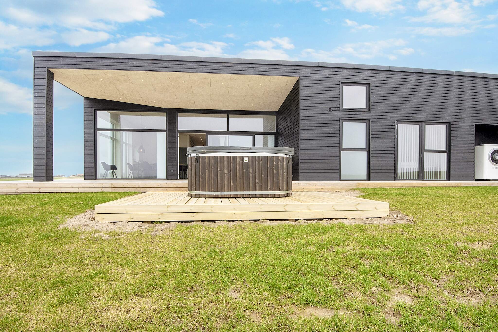 Architect-designed quality holiday home with an eye for detail, built in 2023, with a new wilderness bath for six people and panoramic views of the Limfjord, both inside and outside, located only approx. 300 meters from the child-friendly beach at Gjellerodde. 
The holiday home is energy efficient with an air/water heat pump, enabling lower consumption. There is also a charger for electric cars. 
The house's activities provide ample opportunity for many hours of entertainment for both children and adults. There is billiards and table tennis (table to place on top of the billiard table). In addition, darts.
The summer house is bright and inviting and is practically furnished with a combined kitchen/family room/living room. The house has a panoramic view of the fjord from several of the rooms in the house. 
The kitchen/family room features a ceramic hob, extractor hood, separate oven with grill, microwave, dishwasher, coffee maker, and fridge/freezer.  
The living room has modern furniture, free high-speed internet, and a Smart TV with apps, where you can stream your own TV services. In addition, there are German channels via satellite. 
Bright and beautiful high-quality bathroom with bathtub, shower, and toilet.  Guest bathroom of the same quality with bathtub, shower, and toilet. There is also a washing machine and dryer in the house.  
The cottage has four bedrooms, all with two high-quality single beds. In addition, there is a loft where four children can sleep.
Not available for rental to youth or tradespeople groups.