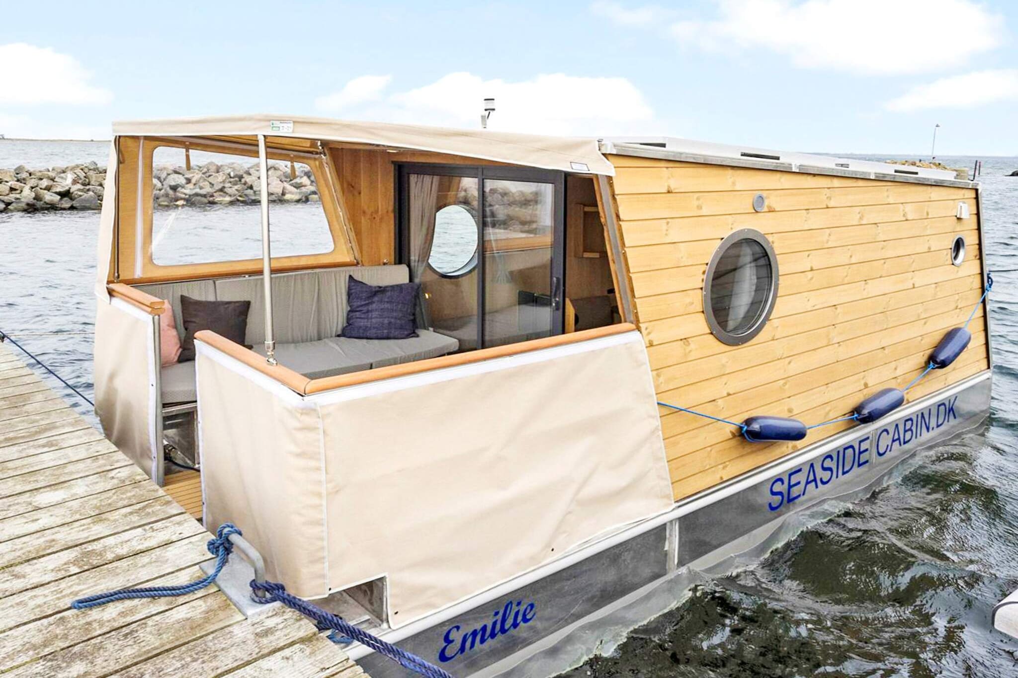 In Ærøskøbing Marina you will find this houseboat of approx. 15 m2. The boat has a spacious living area with all the necessary facilities as well as a nice large sun deck with room for four people, from which you can enjoy the sea view and follow life on the harbour. The houseboat of the Seaside Cabin brand is equipped indoors with a multifunctional sofa arrangement which can easily be converted into two sleeping places, lots of cupboard and drawer space, a kitchen (galley) with sink, fridge and hob (220V). There is also a bathroom and toilet on board and the boat is of course fully utilized in all corners. There is a sofa under the canopy outside, which can easily be converted into two extra sleeping places, (max. 175cm) long. The sleeping places outside are nicely covered, but you should be aware that the beds are only 175 cm long. The boat is also equipped with solar panels that provide free electricity for your holiday, and there is free access to the harbor's bathing and toilet facilities, etc. Not for rent to youth groups.A refundable deposit might be charged closer to your check-in date. The security deposit ensures a smooth stay and covers any additional services or consumption charges.This deposit covers utilities consumed during your stay and any additional services that may be taken.The final amount will be adjusted based on actual meter readings, actual usage of extra services, and any remaining balance will be refunded within 21 days after checkout.This deposit simply acts as a prepayment for charges that  you would anyways pay for, ensuring a seamless stay and check-out experience.