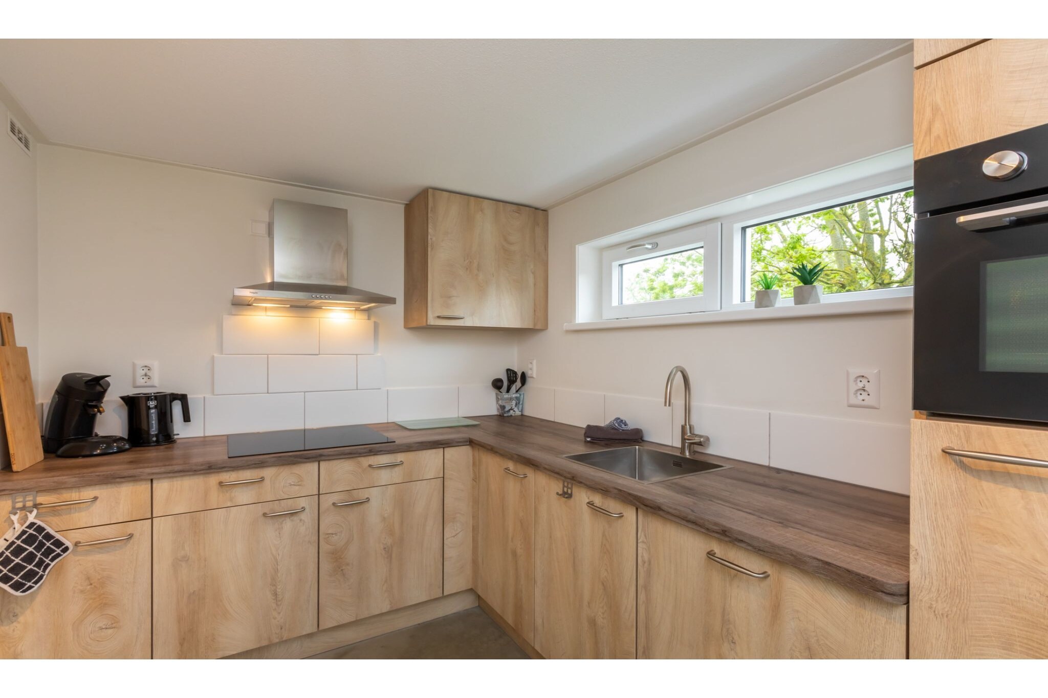 Ground floor: (hallway(toilet), open kitchen(dining table, electric kettle, cooker(induction), coffee machine, combination microwave, dishwasher, fridge-freezer), Living/diningroom(TV, seating area), Bedroom with bathroom(2x single bed(90 x 200 cm), shower, washbasin), storage(washing machine))\n\nOn the 1st floor: (bedroom(2x single bed), bedroom(2x single bed), bathroom(shower(walk-in shower), washbasin), toilet)\n\nterrace(20 m2), garden(50 m2), garden furniture, parking, children\'s bed