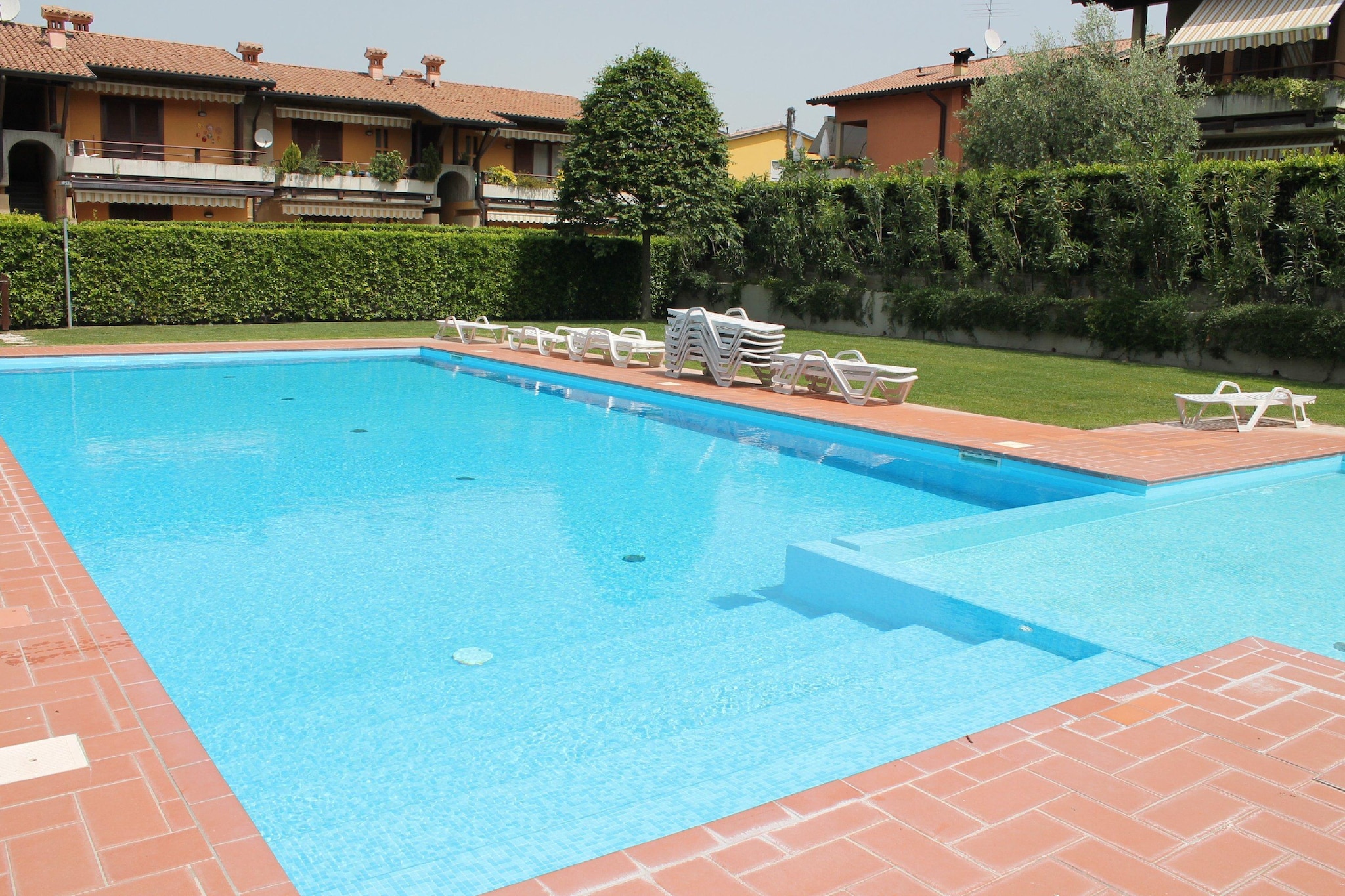 Enjoy a relaxing escape for two in this charming holiday home located in the beautiful lakeside town of Lazise. Set on the ground floor and offering WiFi, the home is perfect for couples looking to explore Lake Garda and its surroundings. With a peaceful setting and all the essential comforts, it’s just a short walk from the lake (800 m) and the town center (600 m).
The apartment features a bright living room with satellite TV, a well-equipped open kitchen, and a cozy bedroom with a double bed. The bathroom includes a shower, washbasin, toilet, and bidet. Central gas heating and air conditioning ensure comfort in all seasons. Step outside to your private terrace, furnished for dining or unwinding, with shared access to a beautifully maintained garden.
Guests can enjoy the large shared swimming pool (16 x 8 m), which includes a children’s section and is open from early May to early September. Restaurants, shops, and public transport are all within walking distance, making it easy to enjoy everything Lazise has to offer without a car. A garage is available for secure parking.