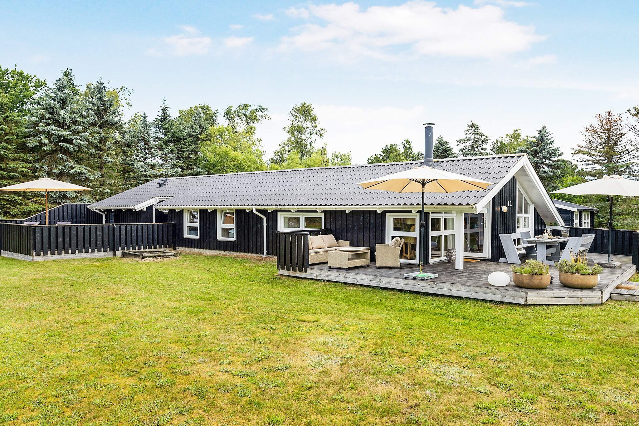 Bright, modern, and well-appointed vacation home with swimming pool, hot tub, and sauna located close to the popular, child-friendly Bratten Beach.
The cottage's pool area includes a large swimming pool, hot tub, and sauna with room for four people. The swimming pool is 15 m² and has a slide for children and a children's pool. There are air-to-air heat pumps, which ensure minimal heating costs in the pool area.  The underfloor heating in the pool room and bathroom is heated with water from an electric water heater.
The focal point of the holiday home is the large kitchen/family room, where the kitchen and living room are combined in one large, bright room. There is plenty of space for cooking in the well-equipped kitchen and the long dining table is perfect for dinner with the whole family. The room also has a cozy sofa group where you can relax and enjoy a movie, a game, or something else. The living room has a wood-burning stove for cold weather and a TV, DVD player, and Chromecast.
The house can accommodate seven people in three bedrooms with comfortable beds, closet space, and TVs. There are also two bathrooms and an outdoor shower.
The terrace around the house is absolutely fantastic, allowing you to enjoy your vacation outdoors. There are two terraces, so you can move around to follow the sun throughout the day. The many secluded nooks are perfect for everything from sunbathing and relaxing to barbecuing on a warm summer evening.
The large terraces invite you to enjoy both the morning and evening sun, the tranquility, and nature in beautiful surroundings.
The house is located on a large plot with trees, where there are swings and a sandbox, so there are plenty of opportunities for relaxation, play, and togetherness.
Not available for rental to youth groups.
