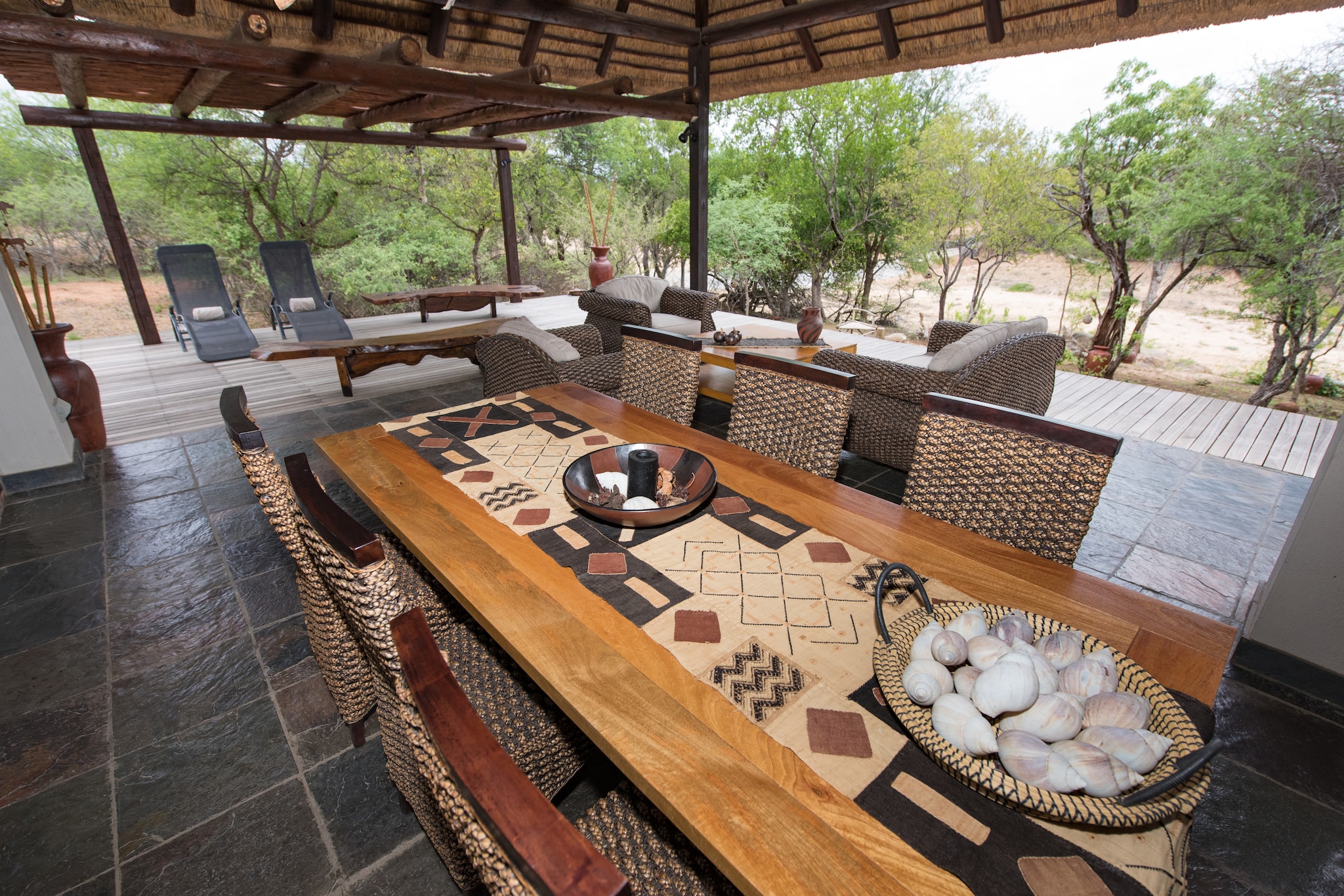 You will find this holiday villa in a unique location on the riverbed. Thanks to its location, there is a good chance of sighting wildlife around the villa.

The decor is African and atmospheric. Beautiful materials have been used. The large terrace is partly covered and has lovely sun beds. There is also a comfortable lounge set and a dining table for 6 people. In addition, the built-in braai is always ready for a delicious meal outside. You can swim in your own heated private pool. The swimming pool is located directly on the terrace. In addition to all this, there is a terrace with a corner sofa on the river.

The three spacious bedrooms have a four-poster bed and a private bathroom with an outdoor shower.

In the kitchen you will find all conveniences; an oven, American fridge and coffee maker. In the utility room you will find a dishwasher, washing machine and tumble dryer.

For the cool evenings, the villa has a fireplace in the living room and a dining table. From the terrace on the river there is a beautiful unobstructed view. The boma completes the day under the African starry sky.

With a Belvilla you are guaranteed a successful holiday. There is always a Belvilla that will give you an unforgettable holiday. We have a surprising and wide range of unique holiday homes for summer holidays, a weekend break or a week's winter sports. The selection consists of more than 40,000 holiday homes in 20 European countries. Unique holiday homes with regional characteristics in beautiful locations, whether by the coast, high up in the mountains or centrally in the city centre. Think authentic country houses with swimming pool in France, special agritourisms in Tuscany, sturdy chalets in the Alps or large houses in the Ardennes. For a family, a couple or for a large group. You will find them in the most beautiful places, so there is enough to do and discover for everyone! We are constantly looking for new houses and new destinations that suit the wishes of our guests.

A Belvilla gives you the freedom to have breakfast in pyjamas or nightly conversations without having to watch the bar closing time. With local ingredients you can prepare the most delicious dishes and in the private pool you can take a relaxing dip whenever you want. In short, all the privacy in your temporary home! And this close to the locals, so you can soak up the atmosphere of the region or village. The homeowner or manager is discreetly your contact person on site and will be happy to give you special tips about the area.