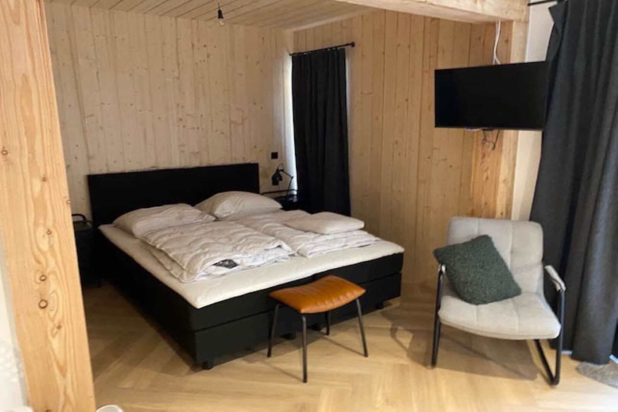 Ground floor: (open kitchen(electric kettle, coffee machine, microwave, fridge(+ freezer)), Living/bed room(double bed, TV(flatscreen), dining table, seating area), bathroom(shower, washbasin, toilet, hairdryer))\n\nstorage, tumble dryer(shared with other guests), washing machine(shared with other guests), parking, party games, Charging post for electric cars