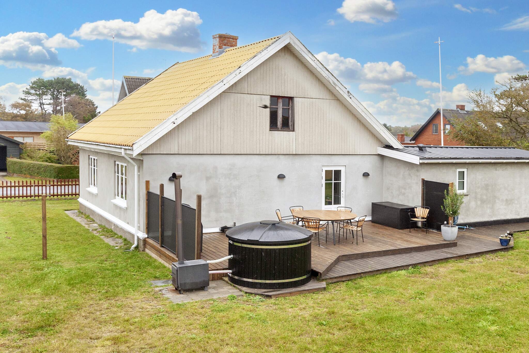 This inviting holiday home is perfectly situated in the heart of the small harbor town of VesterÃ¸ Havn, just 250 metres from the gentle, sandy beach, the ferry terminal, and the cozy harbor area. Its prime location makes it ideal for families or small groups seeking a blend of relaxation and seaside activity. Inside, the house features a spacious, well-equipped kitchen and dining area with a comfortable dining corner where the family can gather for meals or play games together. The living room is bright and welcoming, furnished with comfortable seating, a wood-burning stove, and a TV with Chromecast, allowing you to stream your own content via high-speed internet. The home includes two bedrooms and two bathrooms with showers, as well as a practical utility room with a washing machine and dryer. The interiors combine modern comfort with respect for the propertyâ€™s charming older style. Large windows fill the space with natural light, creating a warm and airy atmosphere. Outside, a large, private garden with multiple terraces offers plenty of space for outdoor living. Relax on the wind-protected terrace with comfortable garden furniture, enjoy meals prepared on the gas grill, or unwind in the rustic outdoor hot tub. Loungers and an outdoor fireplace provide additional spots for relaxation and family fun. Guests can also enjoy the use of bicycles free of charge (note: the owner/DanCenter cannot guarantee their condition). With its combination of seaside proximity, modern amenities, and charming outdoor spaces, this holiday home offers a memorable getaway for families or small groups. Please note: rental to youth groups is not permitted.