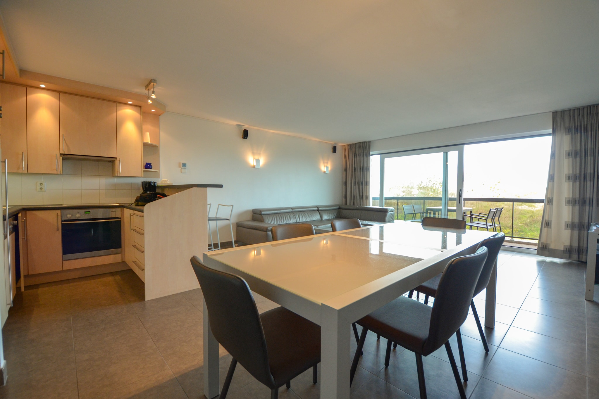 This modern, spacious, and well-maintained apartment provides a comfortable stay with a beautiful side sea view. Designed to accommodate guests seeking relaxation and convenience, it features two bedrooms—one with a double bed and another with twin beds—offering ample sleeping space. The apartment includes two bathrooms, ensuring privacy and comfort for all guests. Large windows fill the living area with natural light, creating a warm and inviting atmosphere. A private garage is available for secure parking. Pets are not allowed, ensuring a clean and peaceful environment.  

Perfectly situated on the dike, this apartment is just a few steps from the dunes and sandy beach, making it an excellent choice for seaside getaways. The area offers numerous walking and cycling paths along the coast, ideal for exploring nature. Nearby, visitors will find a variety of charming cafés, beachfront restaurants, and local markets offering fresh seafood and regional delicacies. The town center is within easy reach, where guests can browse boutique shops and enjoy cultural attractions.  

The apartment features a fully equipped modern kitchen, complete with an oven, microwave, dishwasher, and coffee maker, making meal preparation simple and enjoyable. The two bathrooms, fitted with contemporary fixtures, provide convenience for all guests. A private terrace offers a wonderful outdoor space to relax and enjoy the fresh sea breeze. High-speed internet access ensures connectivity, making this apartment an excellent choice for both leisure and work stays by the coast.