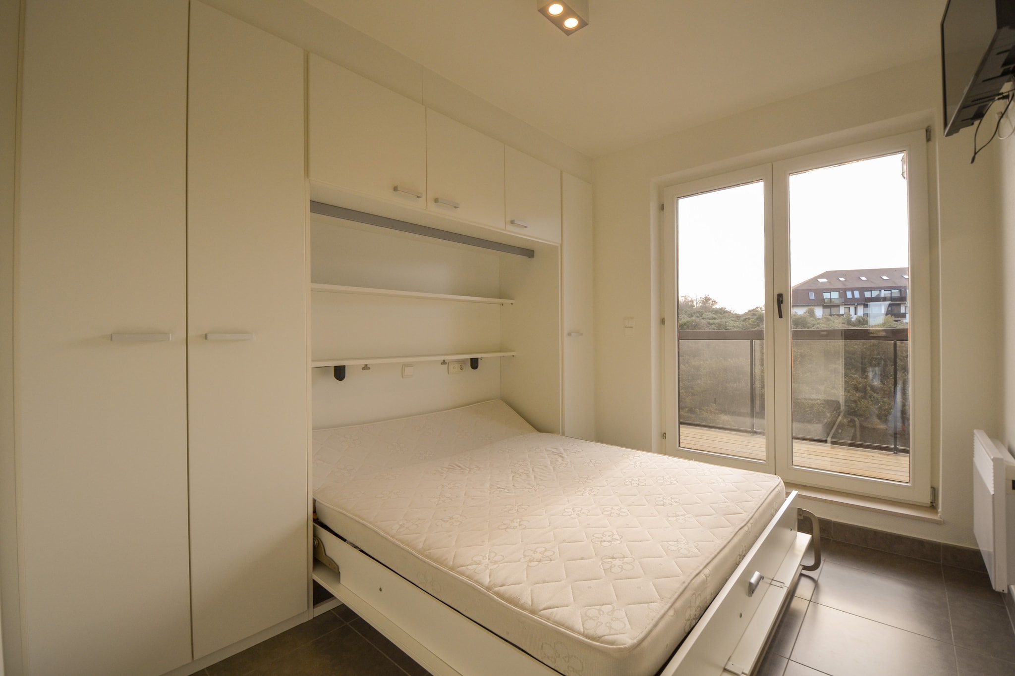 On the 1st floor: (Living room(TV, dining table, seating area, balcony), open kitchen(hob, hood, coffee machine, oven, microwave, dishwasher), bedroom(double bed, TV, balcony), bedroom(double bed, TV, balcony), bathroom(bath tub, shower, washbasin))\n\nstereo unit, washing machine