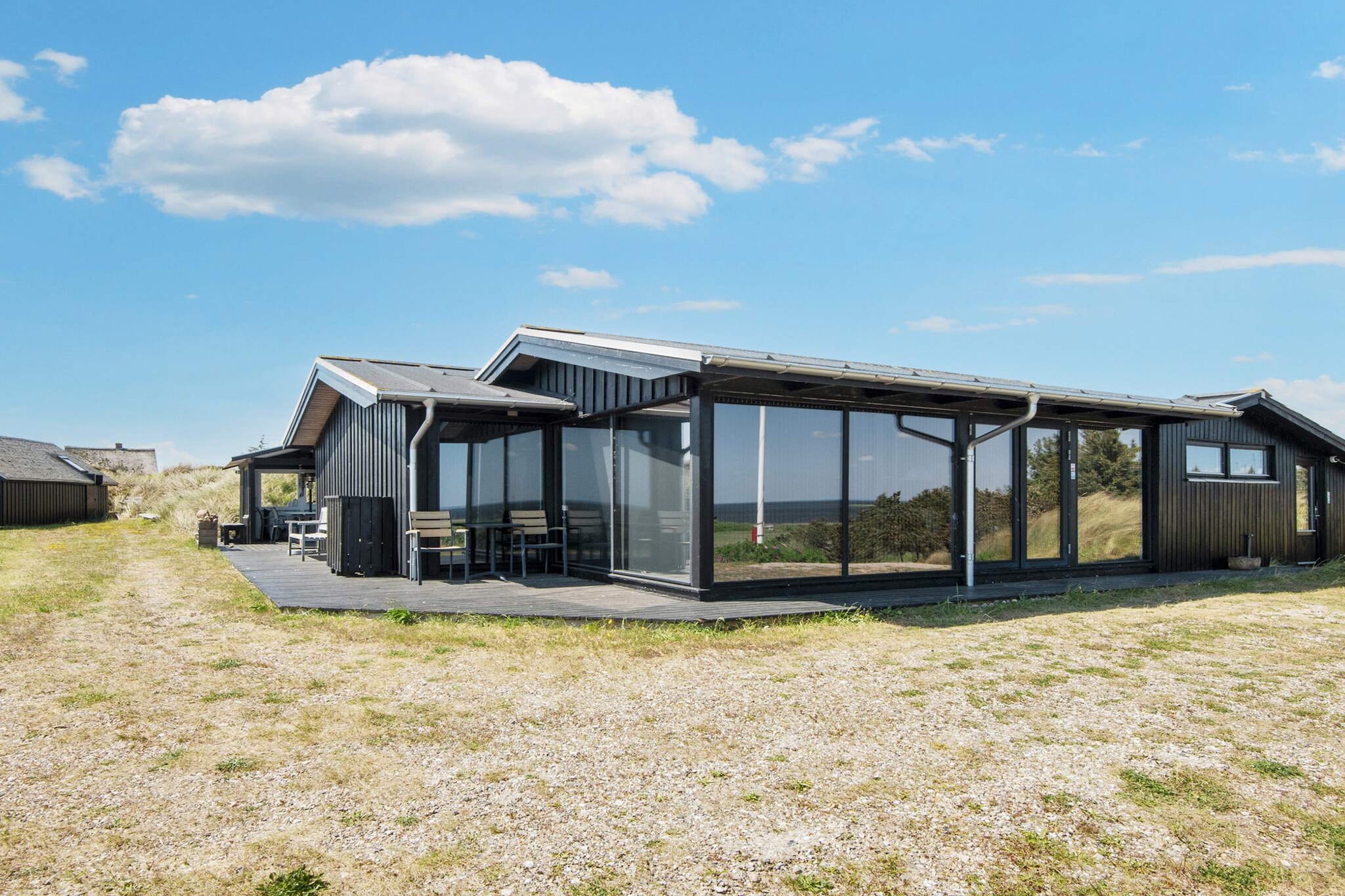Holiday home with a unique panoramic view of RingkÃ¸bing Fjord! The light here is wonderful and it is virtually impossible to take your eyes off the natural surroundings. You can follow the sun as it rises over the fjord in the morning and watch it disappear behind the dunes on the North Sea.
The vacation home for three people is located high up on a dune crest, and a staircase leads you up to the house after you have parked your car below.
The large kitchen-diner has large windows overlooking RingkÃ¸bing Fjord, and the double bedroom also has fantastic views to the south and east. From the TV room, you have a view of the dunes to the west. There is a wood-burning stove in the kitchen-diner. In addition to the double bedroom, there is a room with a nice bunk bed.
The house can accommodate a maximum of 3 people. There is a separate annex with its own bathroom and toilet. The house also has two large bathrooms.
You can sit in beautiful garden furniture on the large terrace facing south, east, and west. On the east side, there is an open terrace where you can enjoy the beautiful summer weather and the beautiful surroundings. Part of the terrace on the west side is covered, providing a perfect cozy corner. A Weber charcoal grill is available.
The west-facing living room and bedroom have Danish, German, Norwegian, and Swedish television. Most of the house has underfloor heating.

There is a cycle path in the area, so you can cycle to Nymindegab or through Hvide Sande and on to Lyngvig Lighthouse. Hvide Sande has good restaurants and specialty shops. At RingkÃ¸bing Fjord, you can surf, water ski on a cableway, and wakeboard. Fishing, the golf course, and Lalandia are within half an hour's drive.

From the vacation home, you can also take walks along the North Sea or trips to Hvide Sande, SÃ¸ndervig, RingkÃ¸bing, or Nymindegab, which offer surfing, water skiing, fishing, dining, and shopping.

Next to the fjord, there is a small harbor measuring 555 m2.

No rentals to youth groups, please!