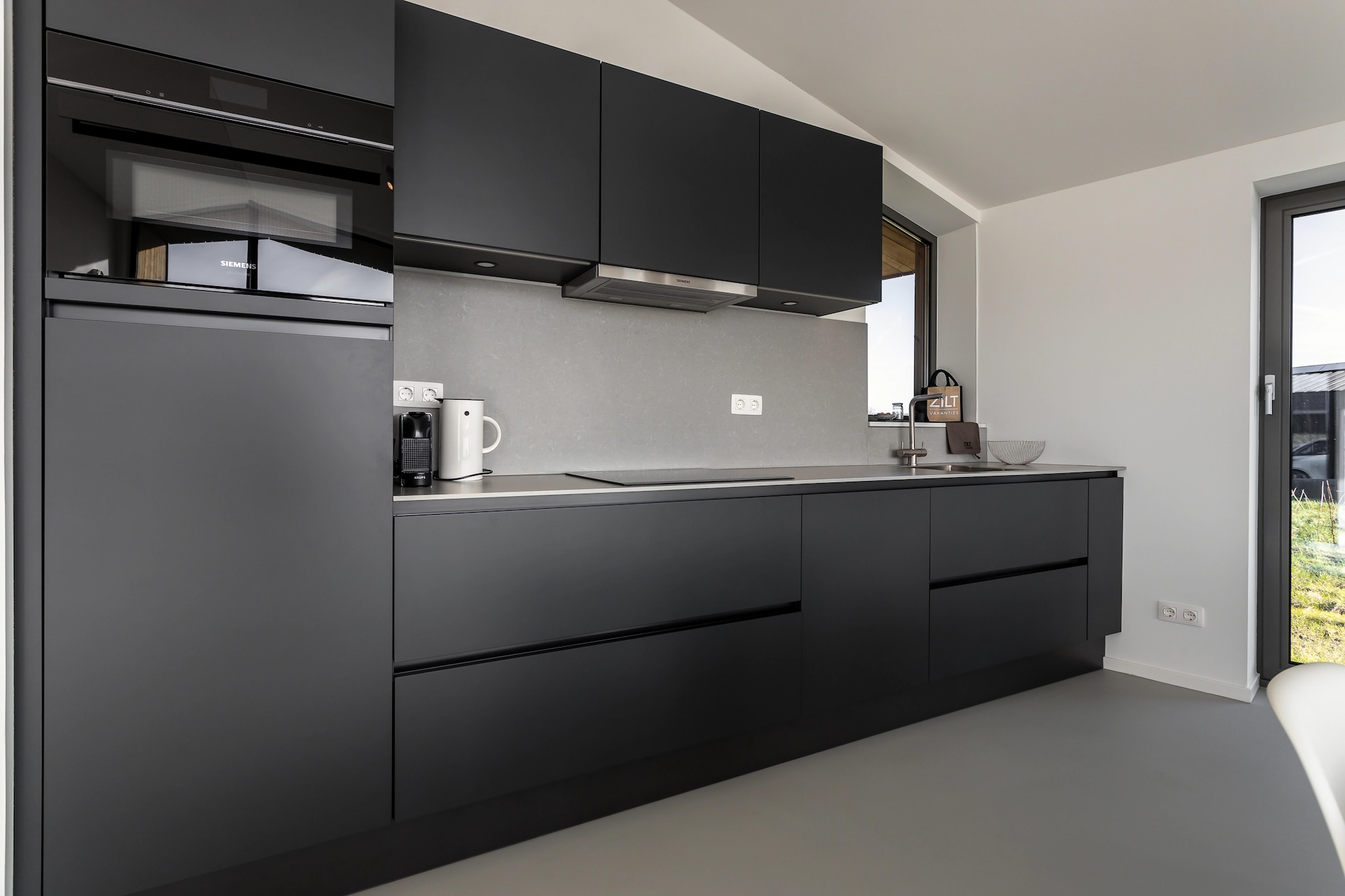 Ground floor: (Kitchen(cooker, coffee machine, oven, dishwasher, fridge, freezer), Living/diningroom(TV, seating area), bedroom(double bed), bedroom(double bed), bedroom(bunk bed), bathroom(shower, washbasin, toilet), bathroom(shower, washbasin), toilet(toilet))\n\nterrace, garden, parking