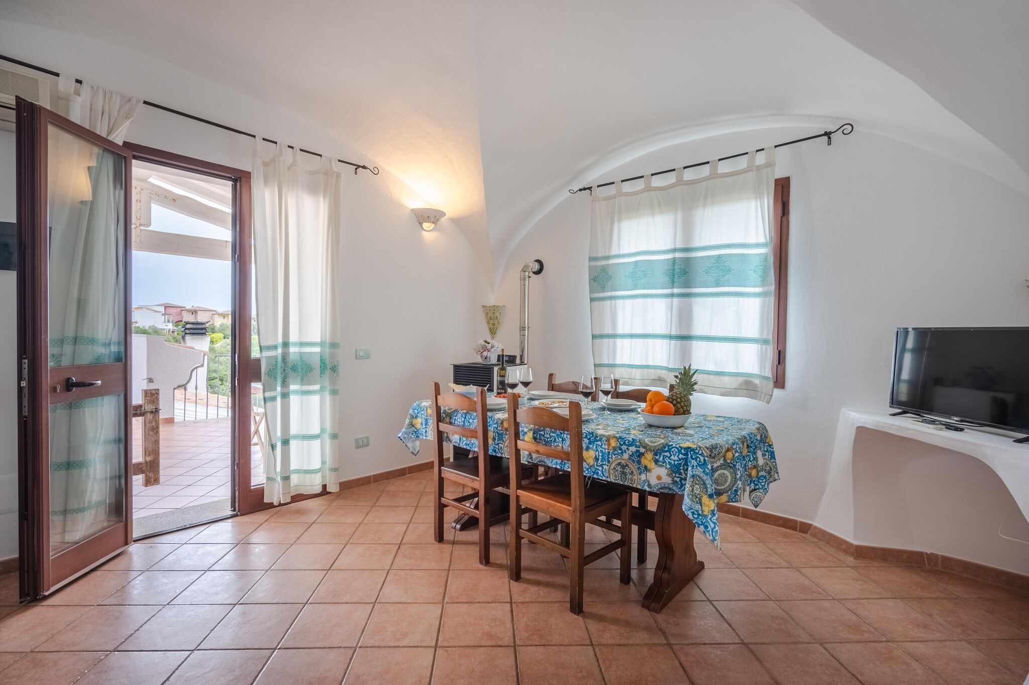 Step into a spacious living room featuring a double sofa bed, perfect for extra guests. Enjoy your favorite shows on the TV, gather around the dining table for meals, or unwind in the cozy seating area. The living room is equipped with air conditioning, ensuring a pleasant atmosphere no matter the weather. The open kitchen is fully equipped, allowing you to prepare delicious home-cooked meals with ease. Modern appliances and ample counter space make cooking a delight. 

Just a short 450-meter stroll to the sea, you can easily spend your days basking in the sun, swimming, or enjoying water sports. Local shops, restaurants, and attractions are also within easy reach, making this apartment a fantastic base for exploring the area. 

Enjoy your meals on the veranda, where a dining table awaits. Savor your food in the fresh air, or recline on the deckchairs and soak up the sun. This outdoor space is perfect for morning coffees, evening cocktails, or simply relaxing with a book. The apartment includes parking facilities, providing convenience and peace of mind for those traveling with a vehicle.