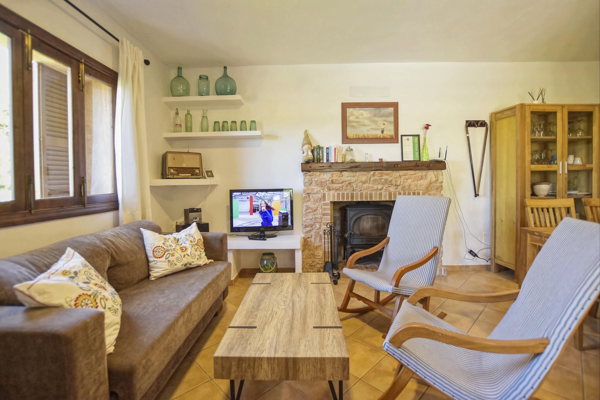This beautiful country estate is in a wonderfully quiet location near the city of Manacor, the second Majorca's largest city on the east coast. With a living area of about 115 m², the house offers a total of three double rooms with air conditioning (1 double bed, 2 single beds each) and two bathrooms with shower, so there is enough space for up to 6 people. The living room is equipped with WiFi Internet, satellite TV satellite, an adjacent dining table and the open-plan kitchen is equipped with ceramic hob, oven, refrigerator, microwave, coffee maker and dishwasher. Two bedrooms and a bathroom are on the ground floor. To the third Bedroom is accessed via an external staircase to the upper floor, which has its own bathroom with shower. From the property's entrance, there are four steps that go down to the beautiful garden with covered barbecue and dining table.  
The surroundings of the farm offer a lot of peace and tranquility to relax and in the closest town of Manacor and its surroundings there are a large selection of very good restaurants, golf courses, various shops and supermarkets. The most beaches nearby are the popular Mallorca coves in and around Porto Cristo, and Sa Coma and Cala Millor are also just 10-15 minutes by car. 
Here you reach the highlight of the Finca, the adjacent terrace with a covered seating area made of benches wood, lots of umbrellas, corner sofas and, of course, sun loungers. The private swimming pool of 9 m x 4.5 m (depth 0.90 m x 1.90 m) invites you to cool off and, behind the pool terrace, there is a hammock between the trees to relax in the shadow. Next to the terrace there is also a guest toilet with sink and two outdoor showers.