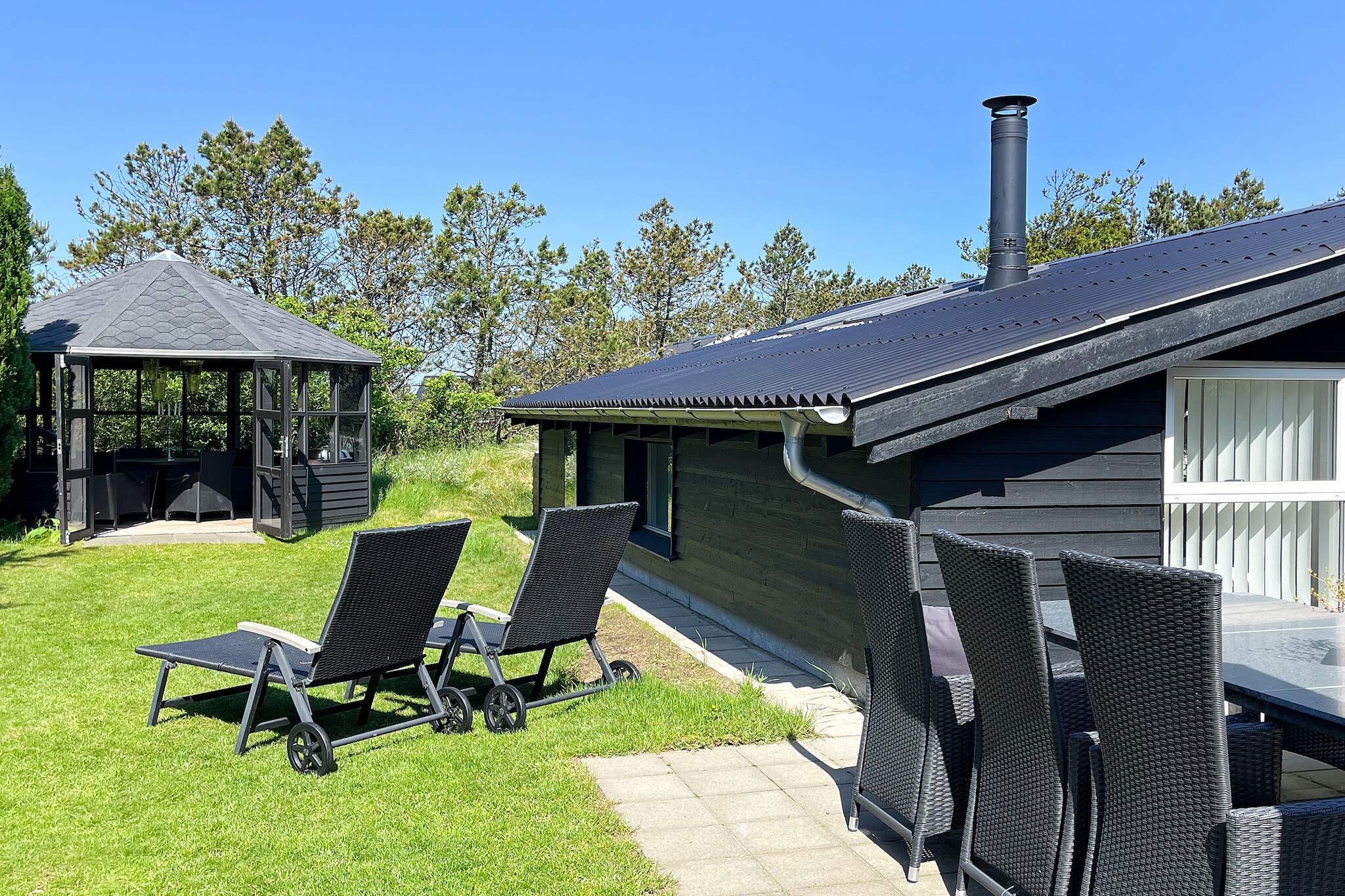 Nestled in the peaceful fishing village of Vorupør, this charming holiday home offers a tranquil retreat just steps away from the wild beauty of the North Sea. Perfect for up to 4 guests, the house exudes warmth and modern comfort, having been lovingly modernized in 2016. Inside, the open-plan kitchen flows seamlessly into a cozy living room where a wood-burning stove beckons you to unwind. The tasteful furnishings, along with a TV and Wi-Fi, make it the ideal place to relax after a day of adventure. Large windows in the living area invite natural light and offer serene views of the garden, while the sunroom provides a perfect spot to watch the changing sky. Set on a spacious 1200 m² natural plot, this holiday home offers an idyllic escape. Wander through the charming garden, find a quiet nook to read, or gather with loved ones in the large gazebo to extend the summer evenings with laughter and stories. The sun-drenched terraces, some with sheltered spots, are perfect for al fresco dining, whether you're grilling fresh fish or simply enjoying the fresh sea air. The house is a haven for those seeking peace, yet brimming with the little touches that make every stay memorable. It’s a non-smoking home and is not available for youth or work groups, ensuring a tranquil experience for all guests. In Vorupør, time seems to slow down. Watch the local fishermen haul in their catch, and wander the sandy beaches as the waves kiss the shore. The nearby Thy National Park, with its vast open dunes and peaceful forested areas, invites you to explore on foot or by bike. Discover the local history at the Vorupør Museum or enjoy the marine life at the North Sea Aquarium. For a touch of excitement, head to the nearby surfing haven of Klitmøller, known as Cold Hawaii, or take a fishing trip to the famous Det Gule Rev. Whether you're seeking adventure or simply a place to unwind, this idyllic coastal getaway has everything you need for a perfect escape.A refundable deposit might be charged closer to your check-in date. The security deposit ensures a smooth stay and covers any additional services or consumption charges.This deposit covers utilities consumed during your stay and any additional services that may be taken.The final amount will be adjusted based on actual meter readings, actual usage of extra services, and any remaining balance will be refunded within 21 days after checkout.This deposit simply acts as a prepayment for charges that you would anyways pay for, ensuring a seamless stay and check-out experience.