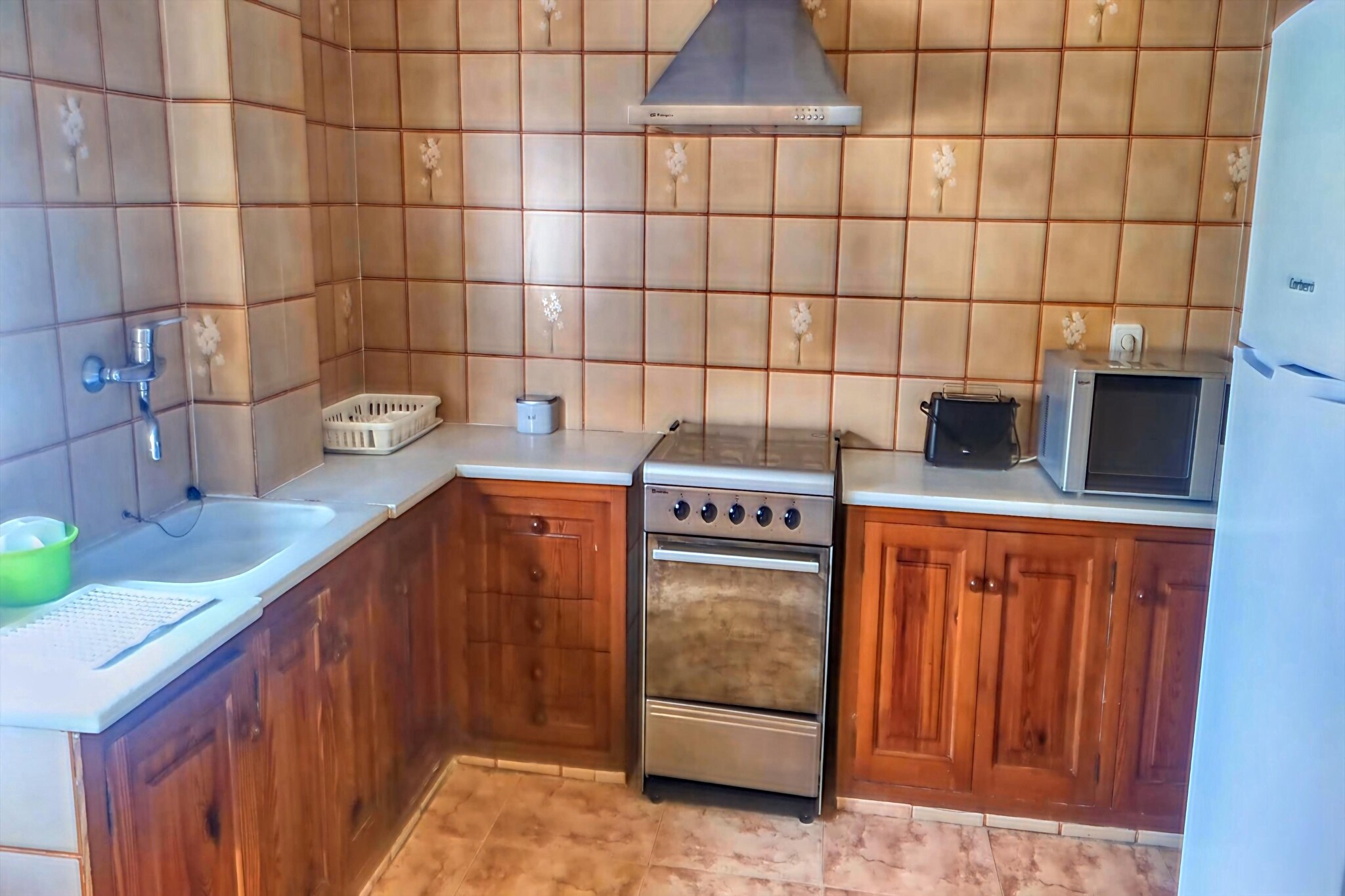 Welcome to your inviting haven on the first floor, where comfort and convenience await you at every turn. Step into the welcoming living room, complete with a TV for entertainment, a spacious dining table for family meals, and a cozy seating area where you can unwind after a day of adventure. Stay cool and refreshed with the soothing air conditioning, ensuring a comfortable atmosphere throughout your stay. Step outside to the serene garden, a tranquil oasis where you can relax and unwind with your family. Whether you're enjoying a leisurely breakfast al fresco or simply soaking up the sunshine, this outdoor space is the perfect spot to create lasting memories.
With the sparkling sea beach just a short stroll away and the vibrant center within easy reach, you'll find yourself perfectly situated to explore all that this charming destination has to offer.
The well-equipped kitchen invites you to channel your inner chef, with all the amenities you need to prepare delicious meals for your loved ones. From hearty breakfasts to gourmet dinners, cooking in this kitchen is a breeze. Retreat to comfortable bedrooms, where peaceful sleep is guaranteed. For added convenience, a washing machine is provided, allowing you to keep your clothes fresh and clean throughout your stay.