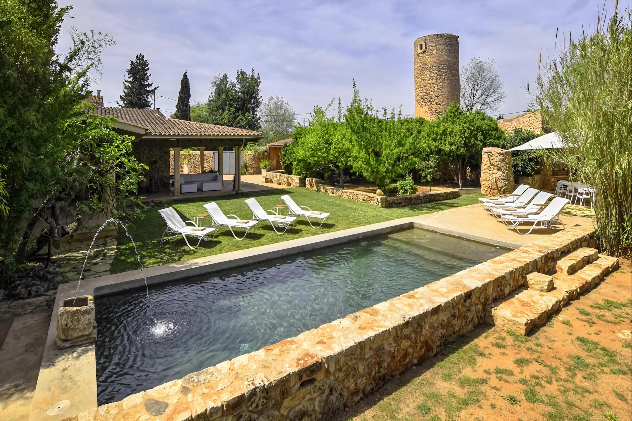 This unique mill estate in the village of Sencelles welcomes you with a particularly elegant and at the same time very traditional ambience. Great importance was placed on preserving the original style and complementing it with modern and luxurious comfort. It is ideal for a group of family or friends of 8 guests. A beautiful idyllic garden tempts you to spend a lot of time outdoors in lush green garden and beautifully designed terrace. The fantastic 10m x 4 m pool is elegantly embedded in the middle of the garden and provides the necessary refreshment after a well-deserved sunbath. A small fenced part of the garden is home to the Mallorcan tortoises that belong to the finca. 

The property, basically designed as a rural finca, is located in the village of Sencelles.  privacy and yet very good infrastructure connections. The village of Sencelles, which has about 3.000 inhabitants, is situated on the road between Palma de Mallorca and Inca. Definitely you should pay a visit to the weekly market. 

In front of the house stretches the enormous, covered terrace in L-shape, where you can find a lot of peace and shade on the comfortable sofas and at the dining table. From here you can overlook the swimming pool, so you can always see the children splashing around. You can use the brick grill to prepare fresh produce bought at the weekly market in the village. With 270 m2 distributed over two floors, the house offers four spacious bedrooms with their own air conditioning. The rustic and at the same time very well-kept and new interior creates an additional cosy atmosphere.