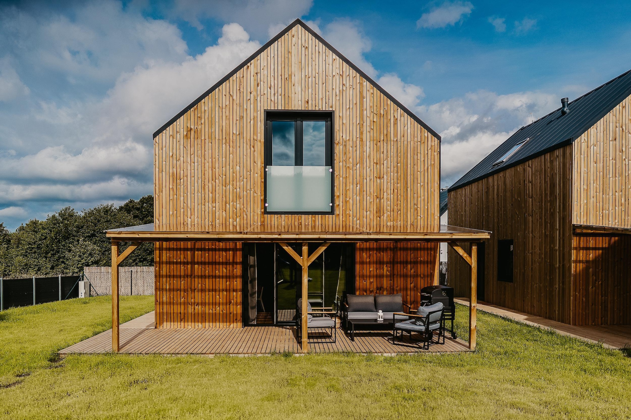 In the town of Nadole, located on Lake Żarnowieckie, guests can enjoy three newly built year-round houses, each with an area of 100 m².
Our houses meet the standards of ecological, energy-saving buildings. Their modern architecture and spacious interior ensure relaxation and comfortable rest. From the accommodation you have access to a private beach.
Thanks to its large area, the house can accommodate up to eight people. On the ground floor there is a fully equipped, modern kitchen, toilet and a spacious living room with access to the terrace. On the first floor there are two large bedrooms and a bathroom with a shower. Two bicycles and a canoe are available per holiday home.
The holiday homes can be used all year round. They have air conditioning with the possibility of heating.
For our guests we have prepared the possibility of booking a heated jacuzzi, which is available to guests all year round without a reservation fee. The only thing that applies is the wood fee. The swimming pool is available in the summer season.