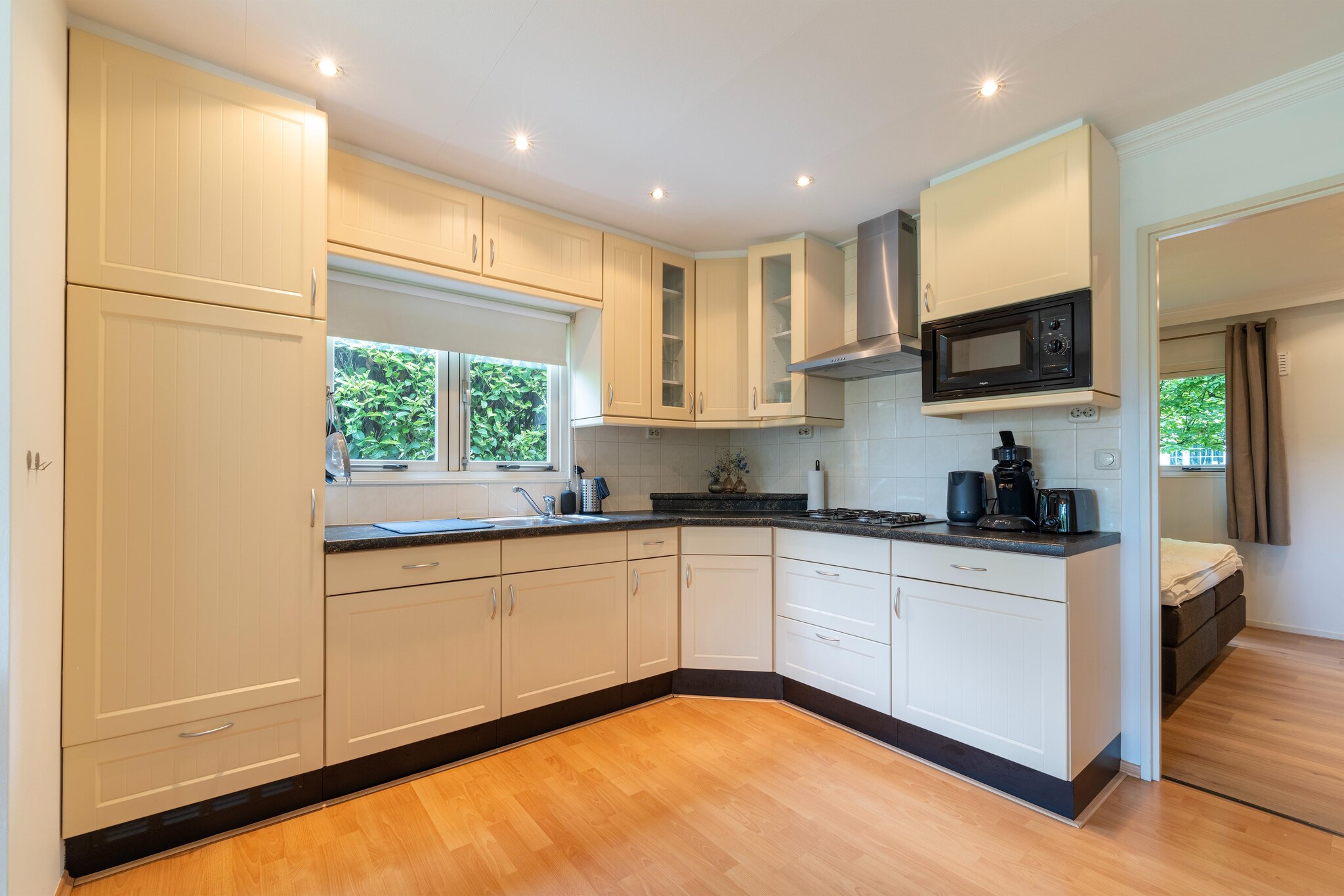 Ground floor: (Kitchen(electric kettle, hood, coffee machine, microwave, fridge-freezer), Living/diningroom(TV, dining table, seating area), bedroom(double bed(boxspring)), bedroom(double bed or 2 single beds), bathroom(shower, washbasin), toilet)\n\nbalcony or terrace, patio, air conditioning, garden, bicycle storage, garden furniture, parking, pond, ironing board, party games, Sunscreen, heating