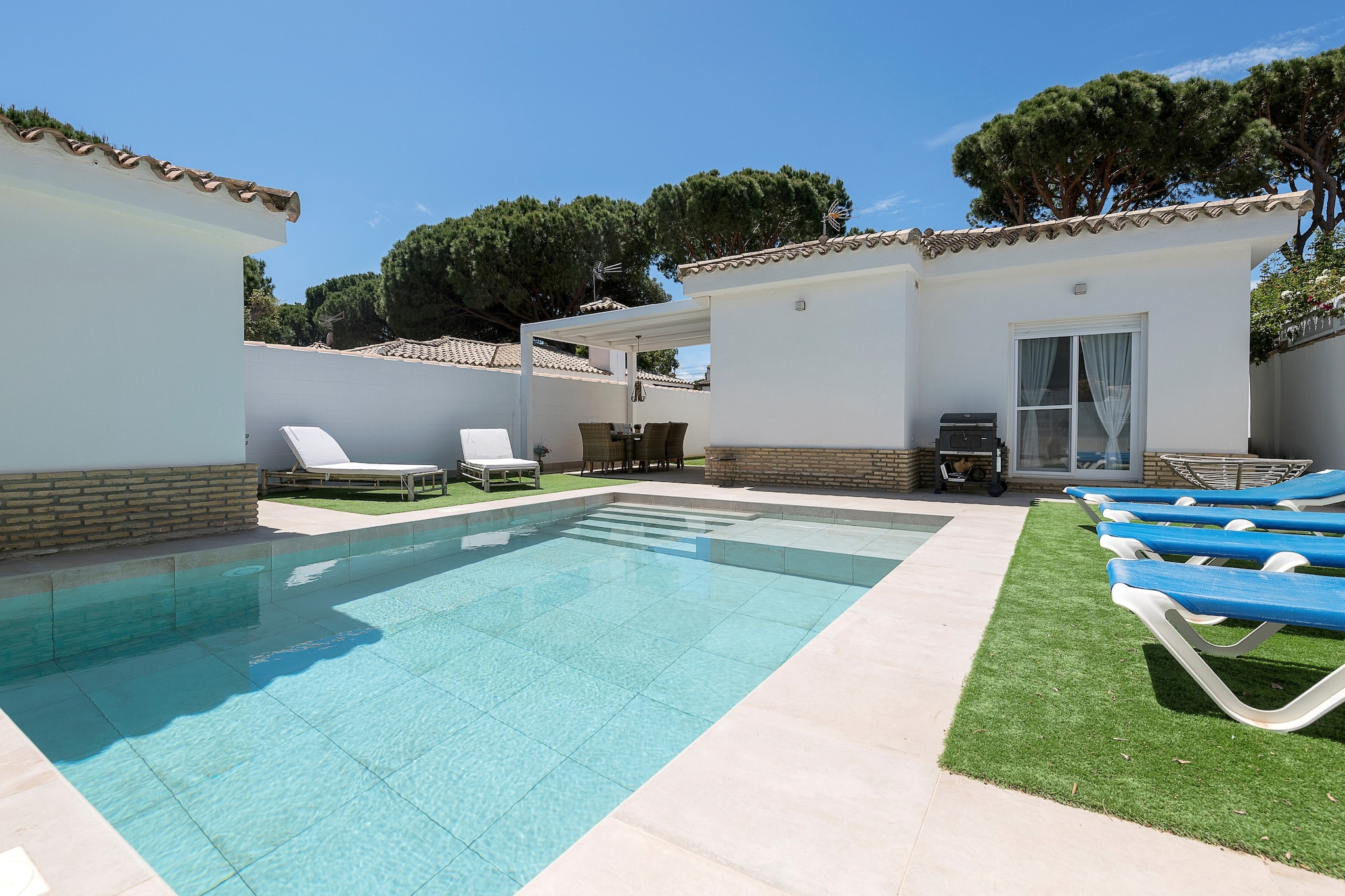 The exterior of the house is perfect for enjoying the southern climate, offering a private chlorine pool measuring 6m x 4.4m with a depth ranging from 1m to 1.60m. If you don't want to get into the pool but need to cool off, you can do so in the outdoor shower and then sunbathe peacefully on one of the loungers. Next to the pool, you can enjoy a delicious barbecue on the porch equipped with a dining table. At the front, you will find a porch ideal for having a drink in the afternoon with your companions. There is a bathroom with a shower outside. The property is fenced and has neighbors nearby.

The interior is distributed on one floor. Upon entering, you will find the dining room equipped with a fireplace, AC, Smart TV, and a table for 6. The ceramic hob kitchen is equipped with all the necessary utensils for cooking comfortably. There is a washing machine, iron, and ironing board. When it's time to sleep, you'll find three bedrooms. Two of them have double beds and the third, located in the external little house, has a bunk bed with two single beds. A bathroom with a shower completes your stay. If you are traveling with your baby, we can provide a crib and a high chair.

The property is located in the Coto La Campa urbanization. In the area towards the beach, you will find some restaurants and beach bars, but if you want to get closer to the center, Chiclana de la Frontera is only 7km away. There you can find all the necessary services for your stay, and you cannot miss visiting the market. Pets are not allowed. The holding of events is forbidden.