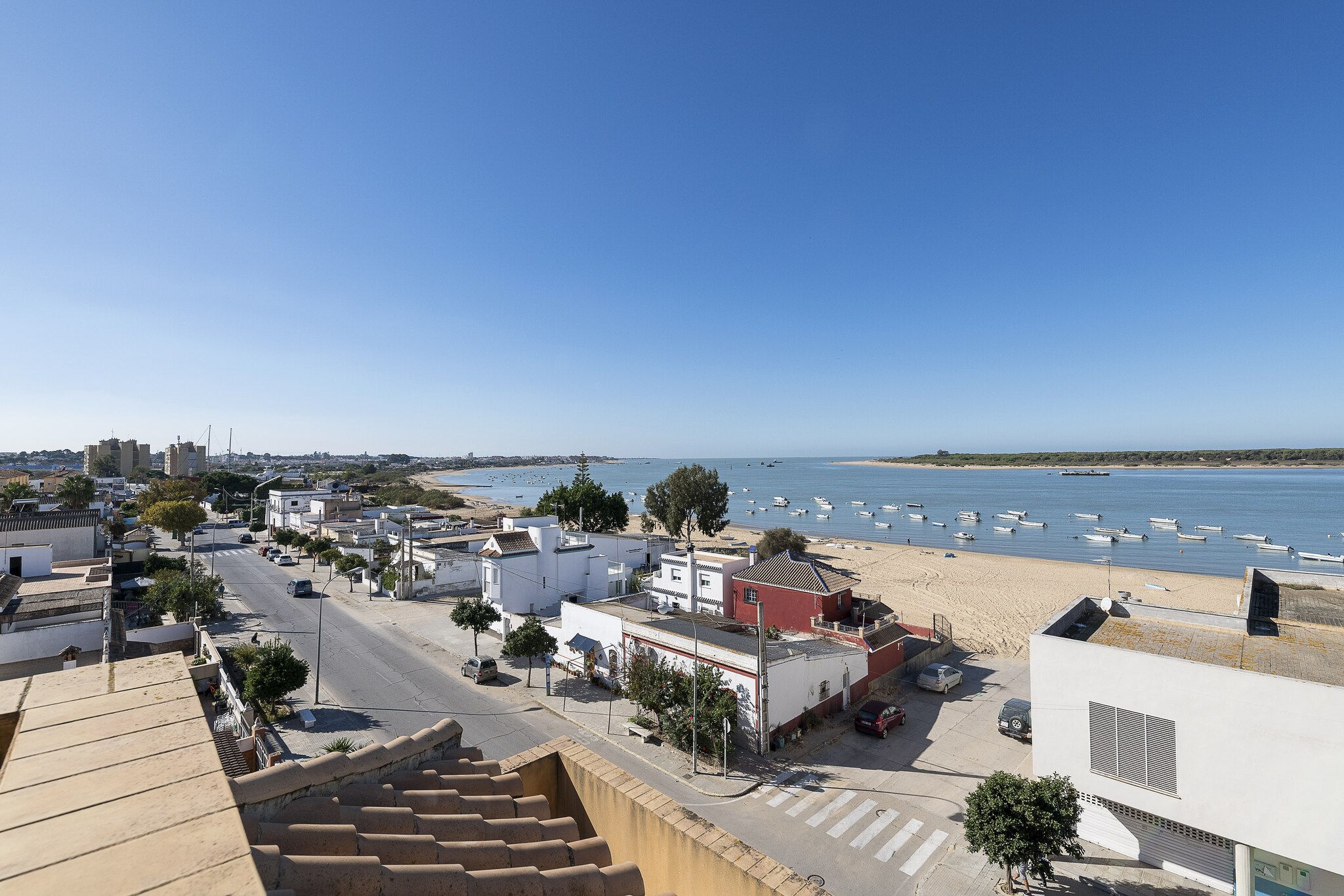 There will be no better way to start the day than having breakfast while contemplating the fantastic views of the Guadalquivir river, the DoÃ±ana reserve and the beach offered by the two terraces that are part of the apartment. In them you will find sun loungers where you can relax while tanning, a barbecue and a large table where you can enjoy eating or having a drink with your companions. Being located in a building, the apartment has direct neighbors.

The bright interior of the flat is designed to offer you the rest you deserve. The living-dining room, equipped with A/C, has radiators and Smart TV and is also open to the kitchen, which has a ceramic hob and all the necessary utensils for you to cook comfortably. There is a washing machine, iron and ironing board in the house. When it is time to sleep, there are two bedrooms, both with radiators. The first has a double bed, while the second is equipped with two single beds and an en-suite bathroom with shower. Up to two more people can sleep on the sofa bed in the living room. There is a separate bathroom with bathtub in the property. If you are travelling with your baby, we can provide you with a cot and a highchair.

The accommodation is located in a quiet residential area of Sanlucar de Barrameda, a coastal town in Cadiz famous for its proximity to the DoÃ±ana National Park, which we encourage you to visit and whose views you can enjoy from the terraces of the apartment. The area has all the necessary services to enjoy an independent stay. In addition, a few kilometers away is the center of SanlÃºcar, where you can enjoy numerous stores, wineries and bars where you can have some tapas. Less than 100 m from your accommodation is Bonanza Beach, a golden sandy beach with calm waters located at the mouth of the Guadalquivir River, where you can also find the salt marshes and wetlands of the DoÃ±ana Environmental Protection Area. Consult the advertiser for possible charges. Pets are not allowed. The holding of events is forbidden. 
Distances
Beach: 0.097 km - Playa de Bonanza
Airport: 36.8 km - Aeropuerto de Jerez
Golf course: 4.4 km - Club de Campo y Golf La Luna de DoÃ±ana
Town: 4 km - SanlÃºcar de Barrameda
Train station: 6 km - SanlÃºcar de Barrameda
Bus stop: 5.6 km - SanlÃºcar de Barrameda
Ferry: 3.9 km - Embarcadero paso a DoÃ±ana
Hospital: 4.8 km - Hospital Comarcal Virgen del Camino
Tourist license: VUT/CA/06398Single Rental Registry: ESFCTU00001101000093702800000000000000CTC-20182158028