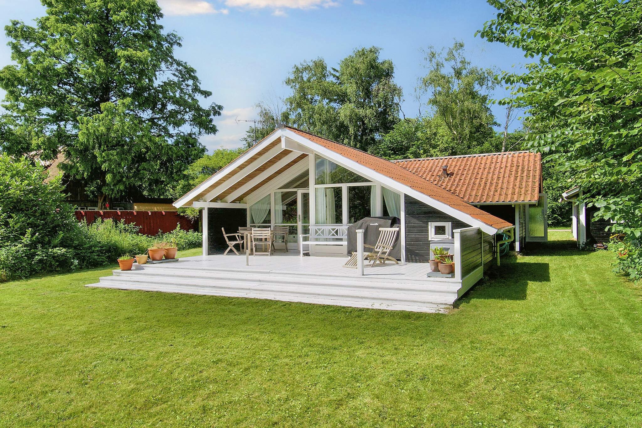 Well-maintained vacation home with whirlpool in the bathroom and outdoor hot tub. Located on Smidstrup Beach. This vacation home offers a great opportunity to relax and enjoy swimming with the whole family or with good friends.
The vacation home includes a practical entrance area/utility room with washing machine, dryer, and microwave. From there, you have direct access to the open kitchen/living room area with an open ceiling up to the ridge and panoramic windows overlooking the garden.
There are three bedrooms; two with double beds and one with a single bed. In addition, there is a sleeping alcove in the living room with a large single bed. A docking station is available for free use in one of the rooms. Beautiful bathroom with whirlpool and heating.
From the living room, you have direct access to a beautiful, large terrace where you can light the barbecue and watch the children playing in the playhouse, playing ball, swinging, or jumping on the trampoline (use at your own risk). On the property, you will also find the wonderful hot tub, where you can sit back and enjoy nature. It is only about 500 m to the beautiful beach and there are also several cozy restaurants in the immediate vicinity.
Not available for rental to youth groups!