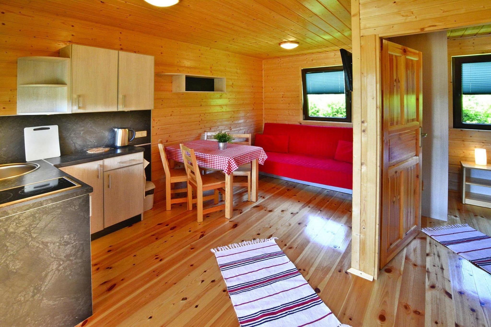 Ground floor: (open kitchen(hob(2 ring stoves, electric), electric kettle, toaster, coffee machine, fridge-freezer), Living/diningroom(double sofa bed, TV(flatscreen, german television channels), dining table), bedroom(double bed), bedroom(3-person bunk bed), bathroom(shower, washbasin, toilet))\n\nPlay area, Lawn, cot, washing machine(shared with other guests, paid), heating(electric), terrace(roofed), garden(shared with other guests, fenced, 6000 m2), garden furniture, sun loungers, BBQ(shared with other guests, charcoal), parking, trampoline(shared with other guests), play equipment(shared with other guests), slide(shared with other guests), table tennis table(shared with other guests), bicycles available(paid), high chair, toys, Swing set, baby crib(paid)