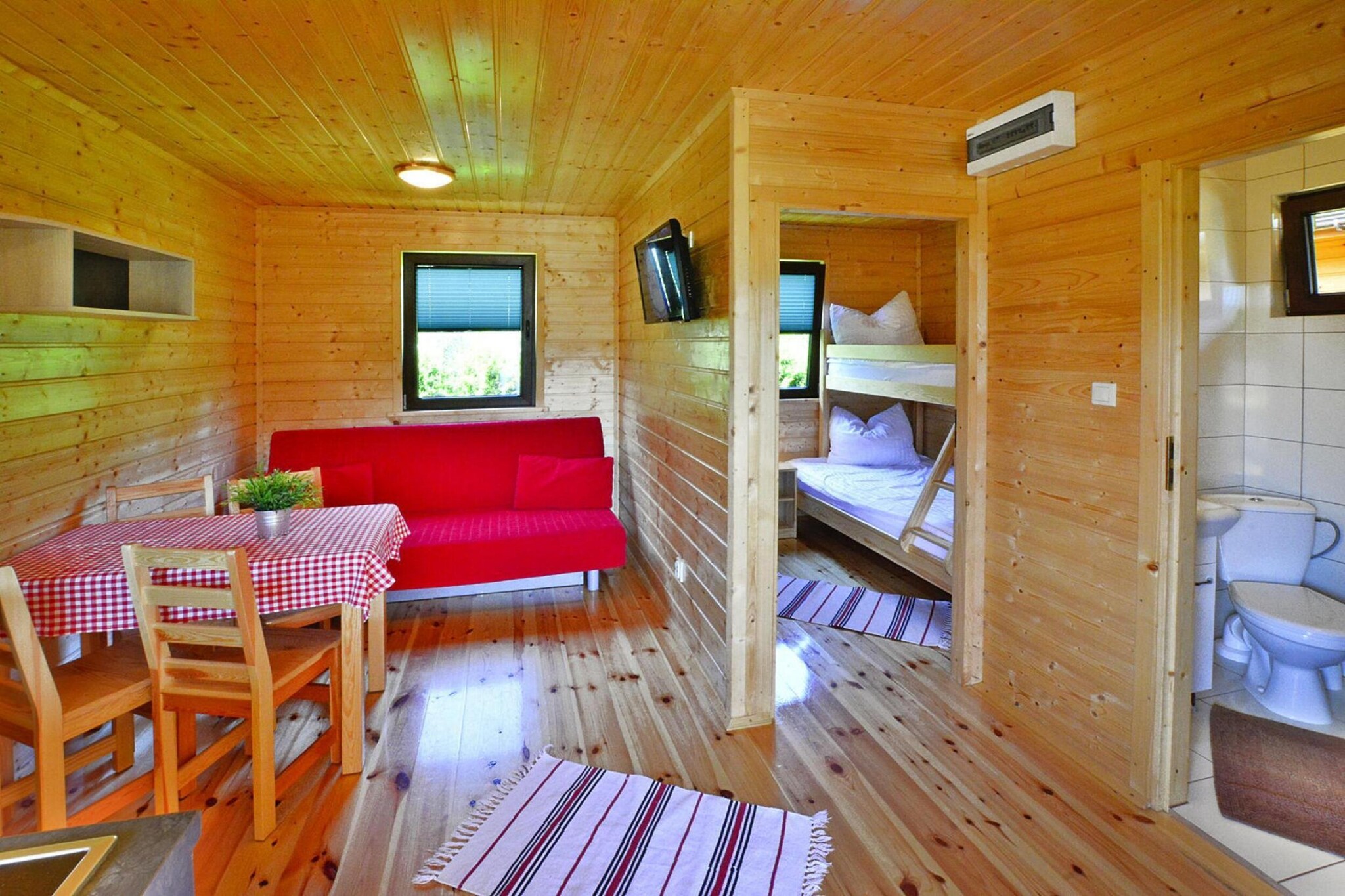 A recreation complex created for families with children. The location on the quiet outskirts of Mielno, close to the beach, the center's equipment with as many as 2 attractive playgrounds, all this contributes to a successful holiday and the satisfaction of older and younger guests of the center.
The single-story houses are very well-kept and nicely decorated. The interior includes a living room with a kitchen, 2 separate bedrooms and a bathroom with a shower. Each house has a covered terrace, a set of garden furniture and deckchairs.
The center has a parking lot, a barbecue area, 2 attractive and safe playgrounds, and a table tennis table.
The price of the stay includes: bed linen, electricity and water consumption, final cleaning, parking, baby cot and high chair (on request).
The beach is only 90 m away. The center of Mielno is approximately 1.5 km away. There you can find many recreational facilities, restaurants and cafes. There are also several shops and bars near the holiday resort.
In the vicinity of the center there is the international bicycle route R-10, which allows you to easily and conveniently get by bike to other neighboring seaside towns: Mielenko, Chlopy (a small, historic fishing village), Lazy, Sarbinowo, Gaski.
300 km from the center there is Lake Jamno with a marina and water equipment rental (pedal boats, kayaks, rowing boats). There are also fishing spots here. This may not be a particularly attractive area for swimming enthusiasts, but it is an ideal place for water sports (windsurfing, kitesurfing - rental and school) and for fishing.