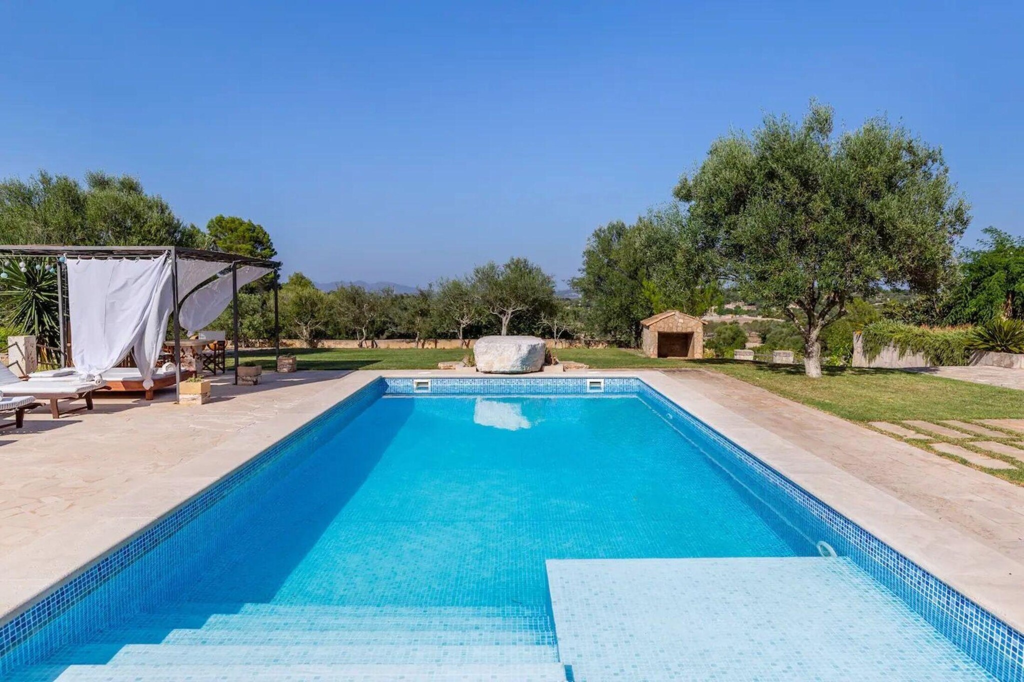 The Finca SON COLOM, dating back to 1896, was previously a manor house with many farms and was restored in 2015 and converted into a wonderful holiday home. This magnificent property is located on the outskirts of Manacor, close to the beautiful eastern coastal region of "Calas de Mallorca" with its fantastic beaches. 

The house with a total living area of approx. 320 mÂ², spread over two floors, has a living-dining room equipped with satellite TV and  WiFi internet, a huge living-kitchen equipped with dishwasher, 5 double bedrooms (4 with ceiling fans, 3 x double bed and 2 x single beds) and a total of 5 bathrooms with shower (3 of which are ensuite). Four of the bedrooms and four bathrooms are on the upper floor and the fifth bedroom and bathroom are in the lower living room. Another bathroom with toilet and shower is located outside the pool house. Furthermore, the estate offers its guests a spacious and beautifully maintained garden with an incredible amount of space. The entire property covers more than 39,000 mÂ², of which 1,000 mÂ² is landscaped as a garden area. 

Surrounded by a 500 mÂ² lawn, the private 10 m x 5 m saltwater pool with its sun loungers invites you to spend a holiday. A shaded seating area, a stone table in front of the house and a brick barbecue offer the possibility of enjoying
al fresco dining. There is also a roof terrace of the tower on the second floor which has been fitted out as a spacious training studio with fitness equipment. Manacor can be reached in just 5 minutes by car and has all the necessary shopping possibilities. The nearest sandy beaches, such as the numerous bathing bays of "Calas de Mallorca" or "Porto Cristo", can be reached quickly and easily by car in just 10-15 minutes.